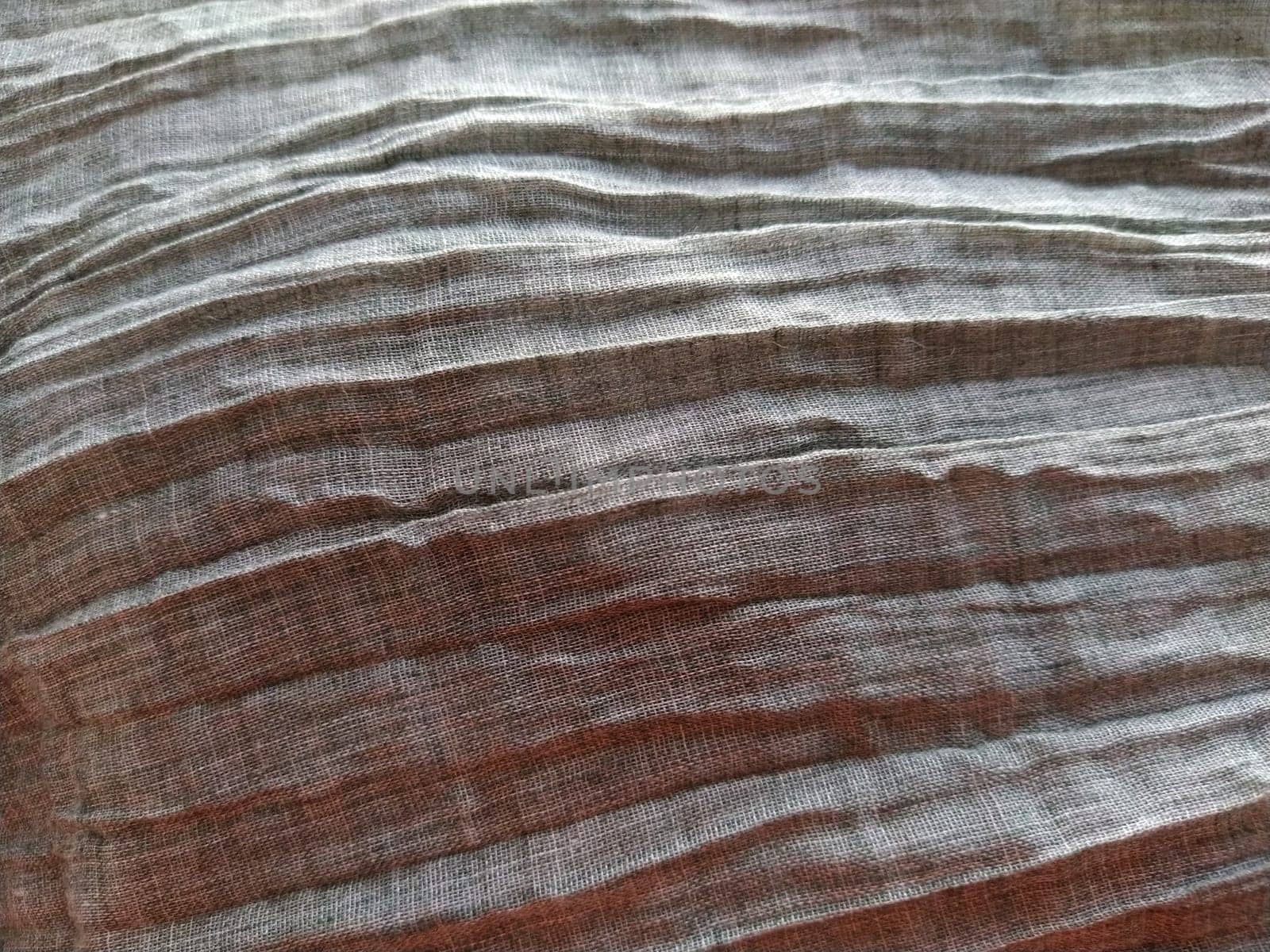 Fabric sheer curtain fabric. Beautiful gray color. The curtain material is carelessly folded and wrinkled. Fabric sample. Interior design option.