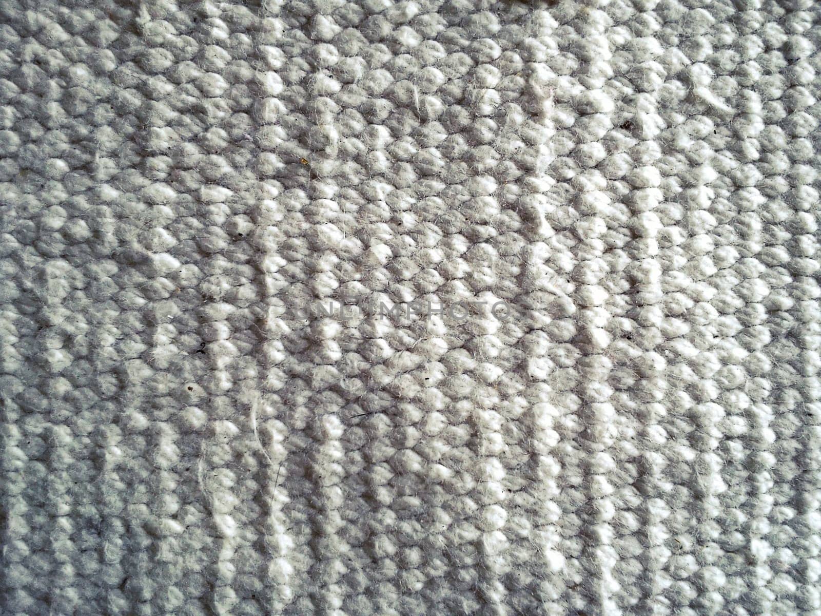 beautiful knitwear in white color. Horizontal rows of front and back loops knitted manually by knitting needles. Soft fluffy warm wool yarn. Close-up.