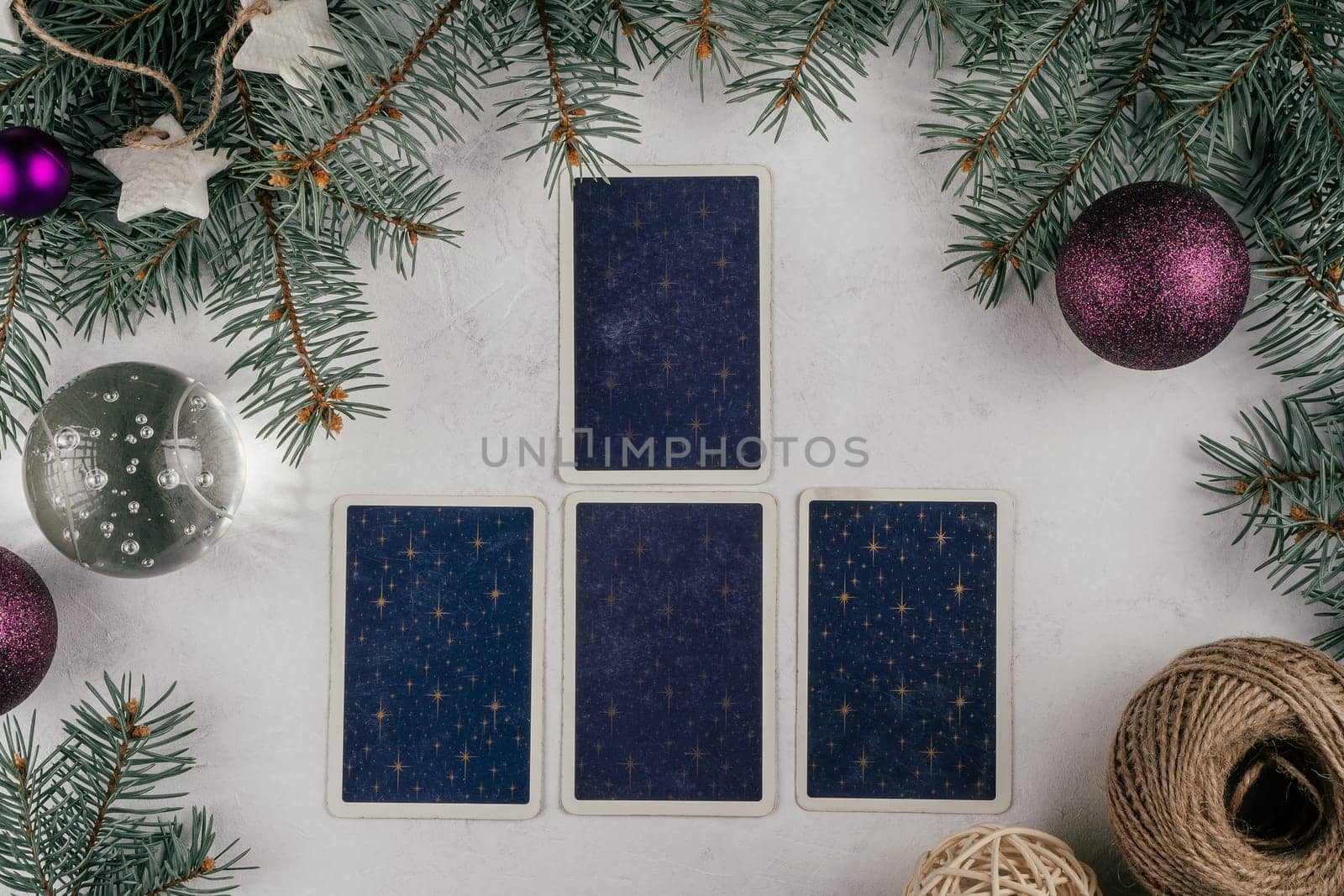 Tarot cards spread on white concrete surface with Christmas tree branches, candles and decorations. Minsk, Belarus, 19.11.2021