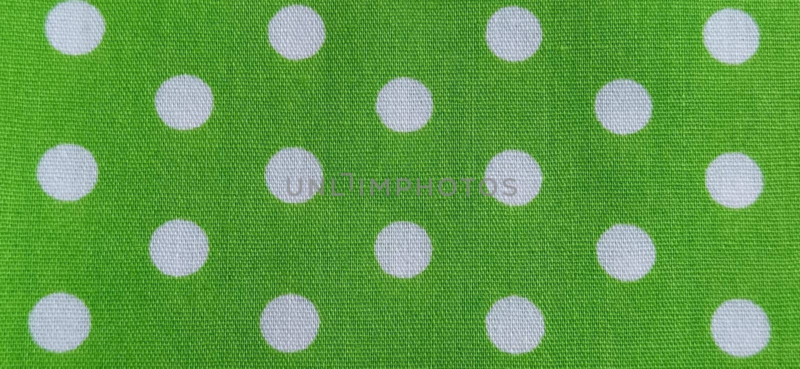 Belgrade, Serbia, 11 September 2020 Green fabric with polka dots. White circles. Close-up. Fabric for sewing dresses and home furnishings. Banner.