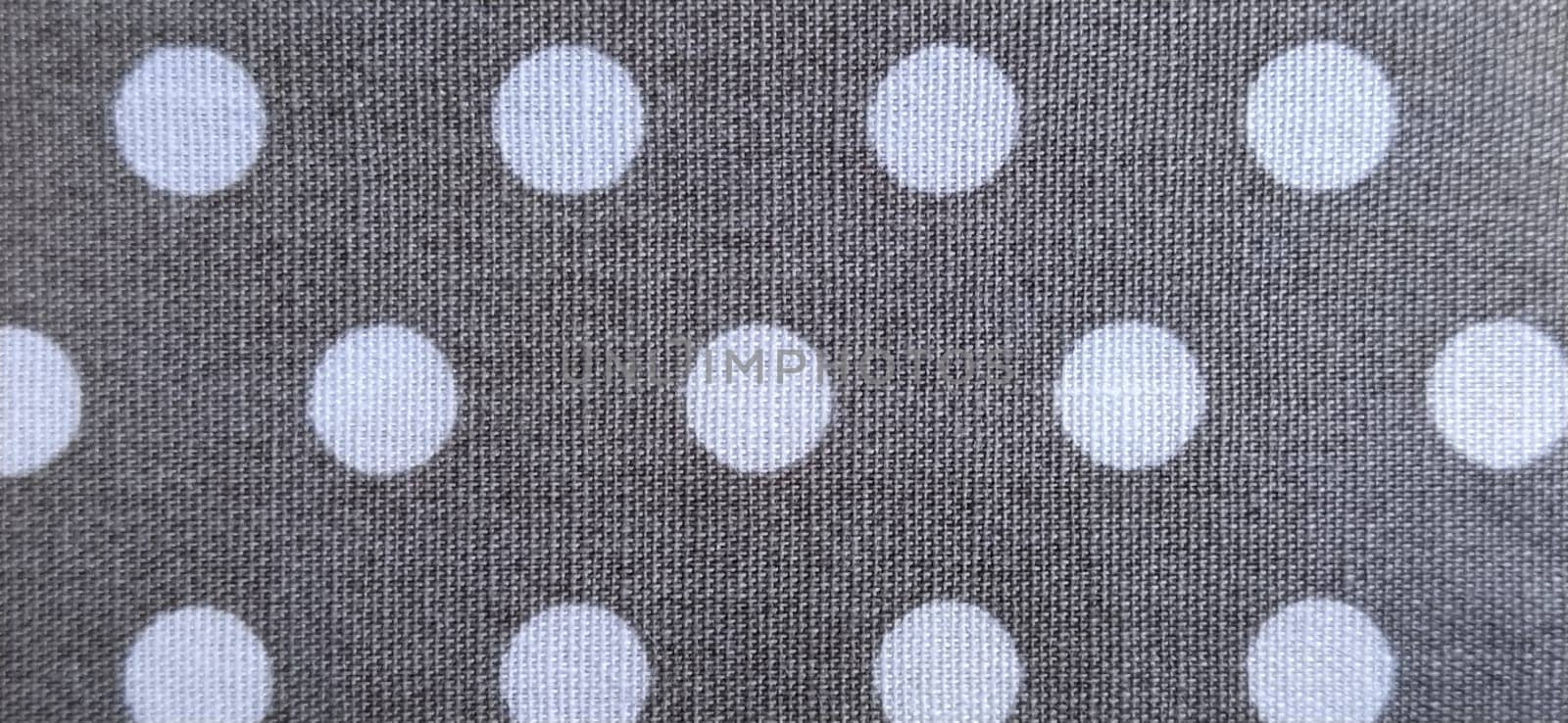 fabric white polka dots on a gray background, smoothed flat surface.
