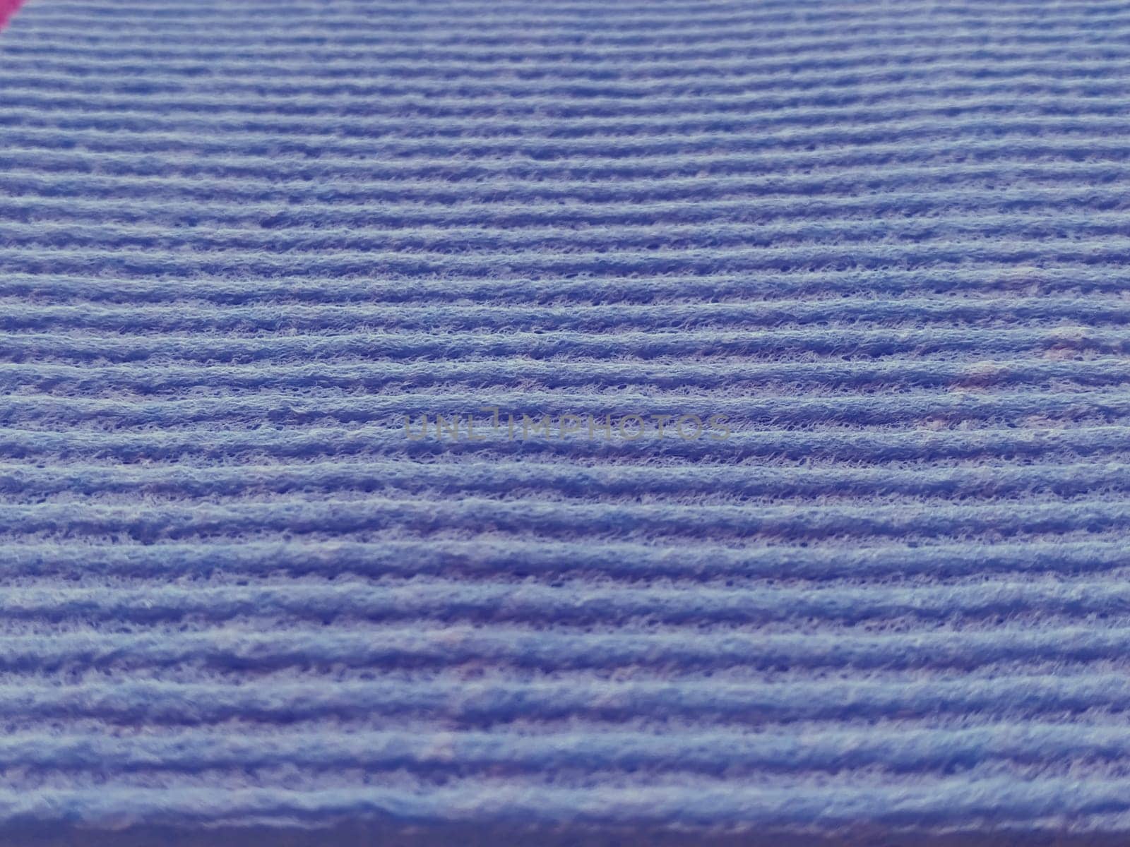 lilac or purple striped ribbed fabric. Close-up shot of a dish washing sponge or microfiber cloth. Soft focus.