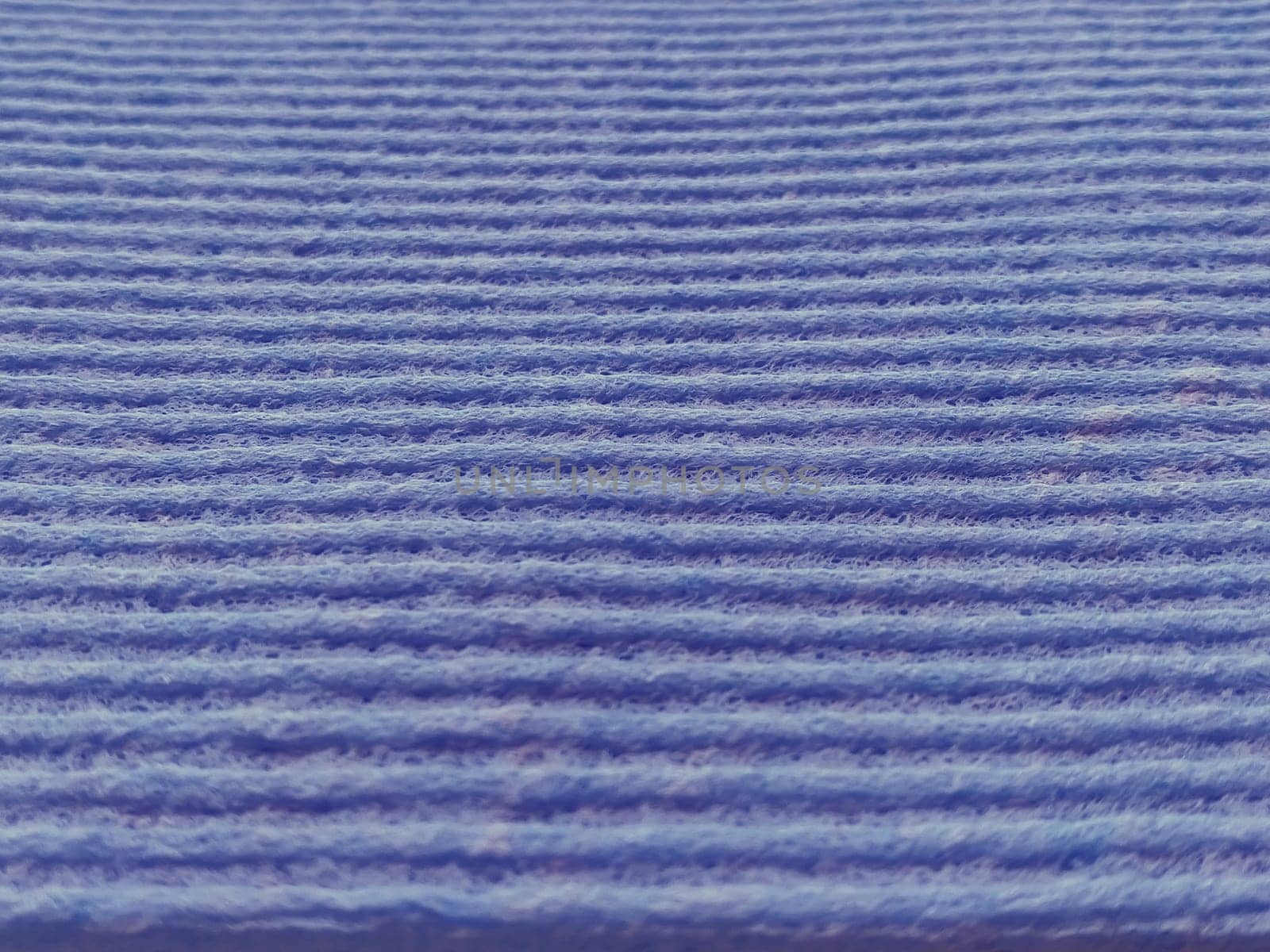 lilac or purple striped ribbed fabric. Close-up shot of a dish washing sponge or microfiber cloth. Soft focus.
