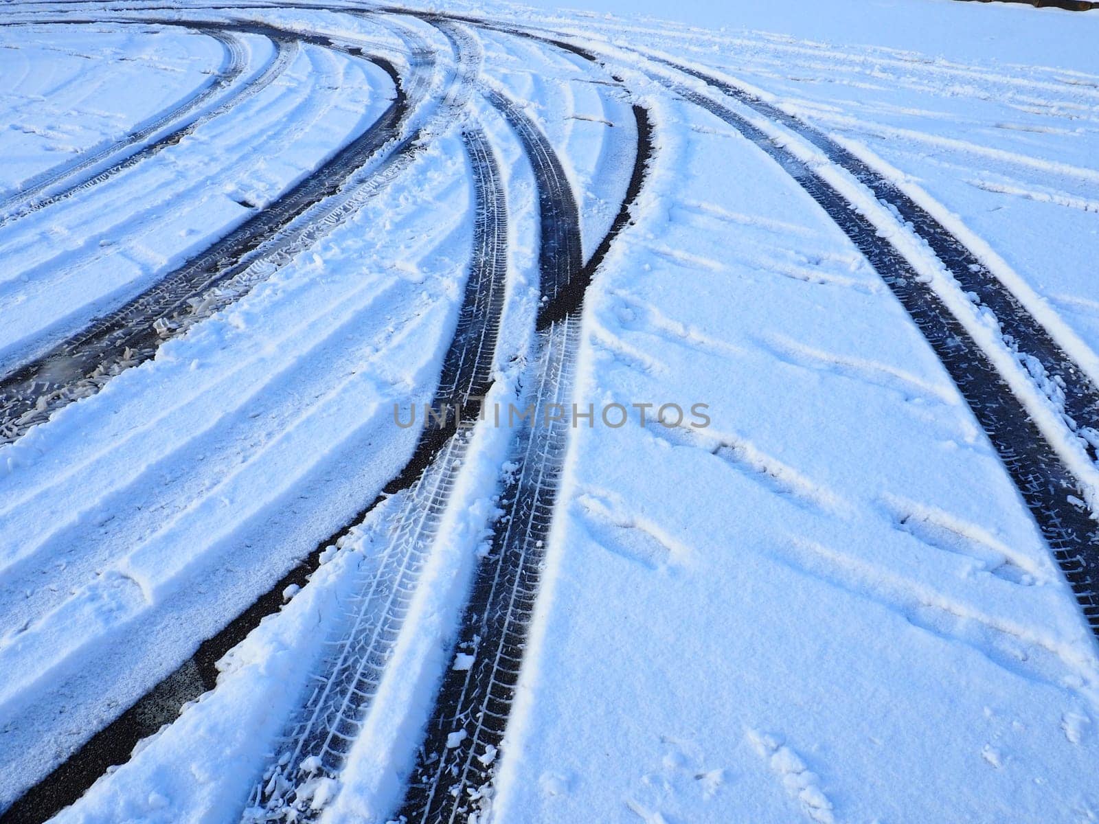 Snowdrifts on the side of the road. Bad weather and traffic. Snow on asphalt. Difficult driving conditions. Winter slosh on the road. Braking distance of a car