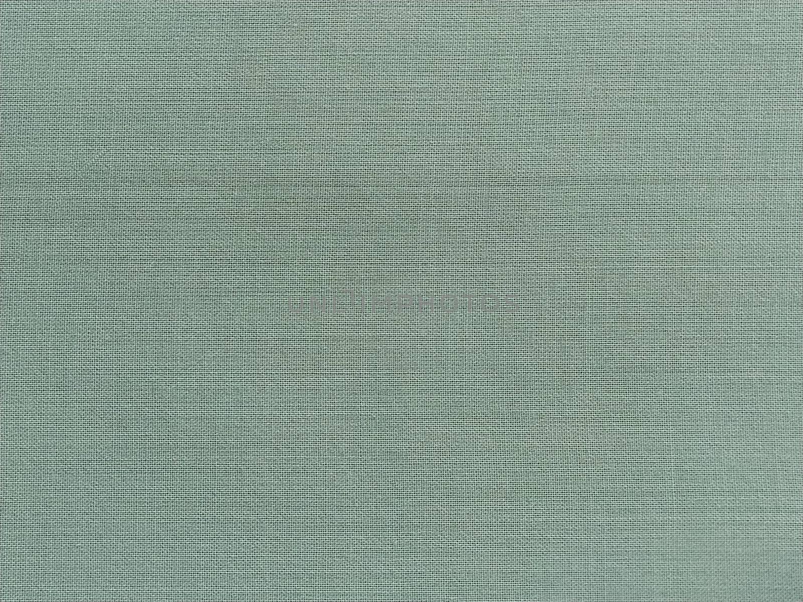 pale light green fabric. A piece of woolen fabric laid out neatly on the surface. Interlacing and textile texture. dress fabric or for kitchen needs, tablecloth or curtains.