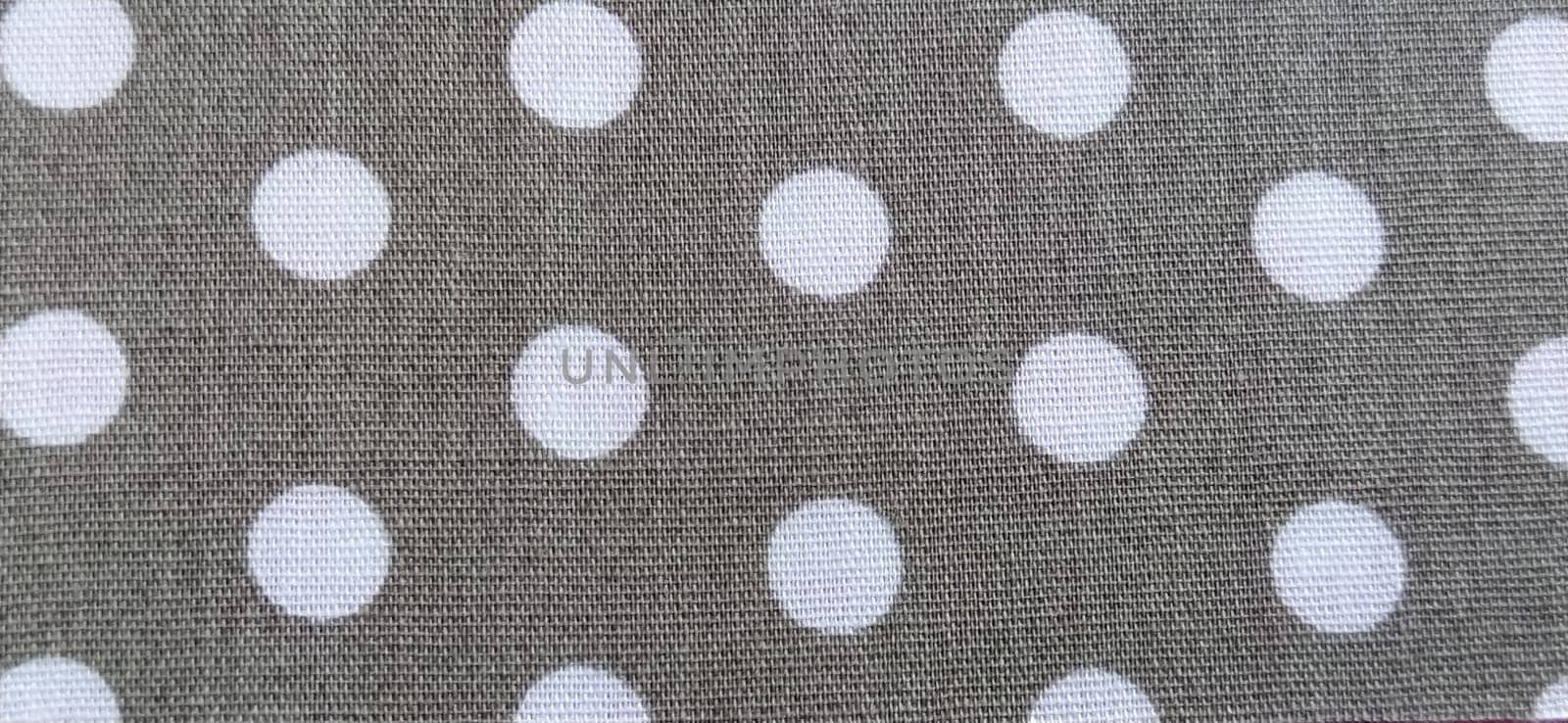 fabric white polka dots on a gray background, smoothed flat surface.