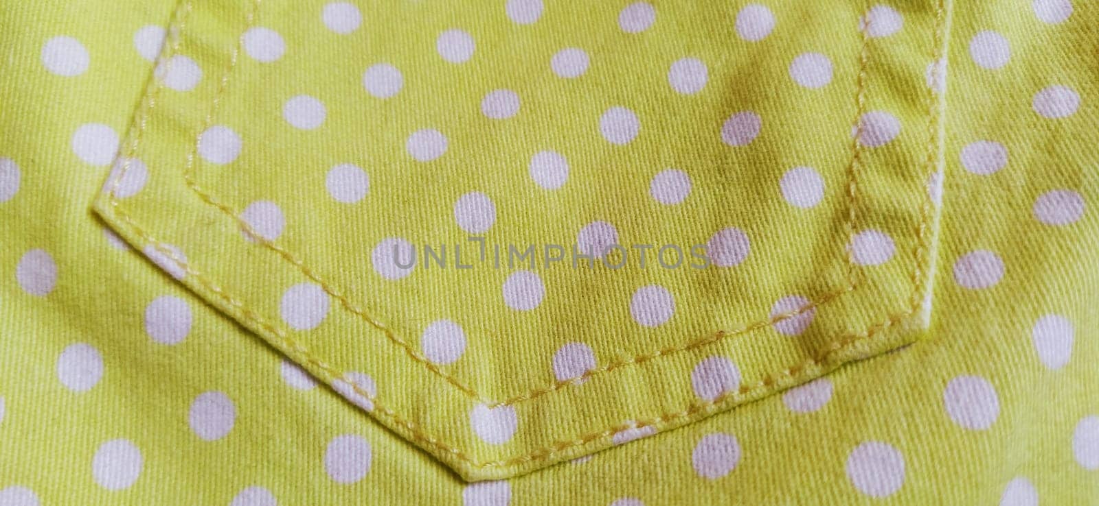 Belgrade, Serbia, 11 September 2020 Trouser pocket. Yellow cloth with white circles. Pockets on denim. Polka dot fabric.