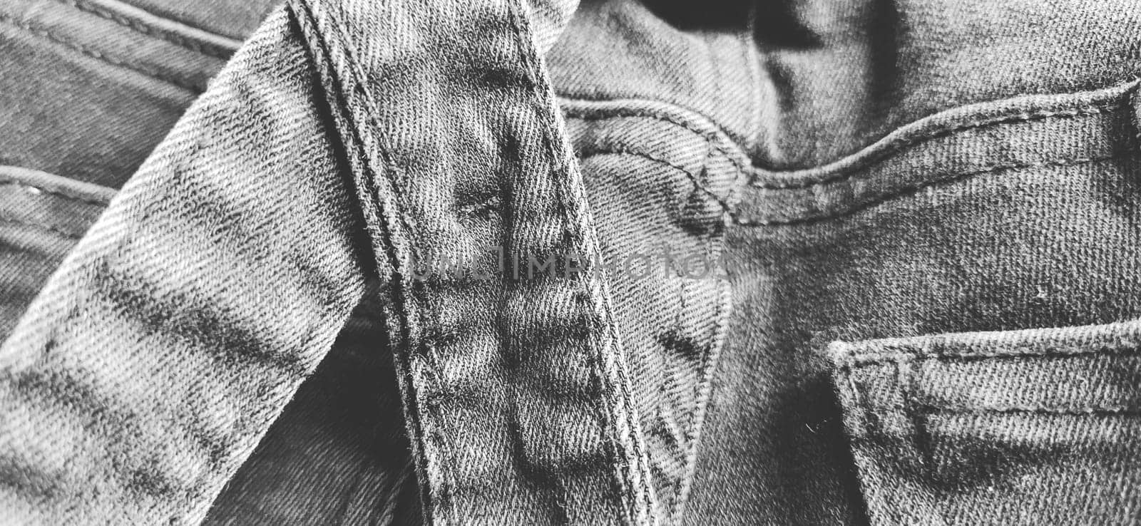 Fashionable denim clothing. Details and seams on rough denim. Black and white photography.