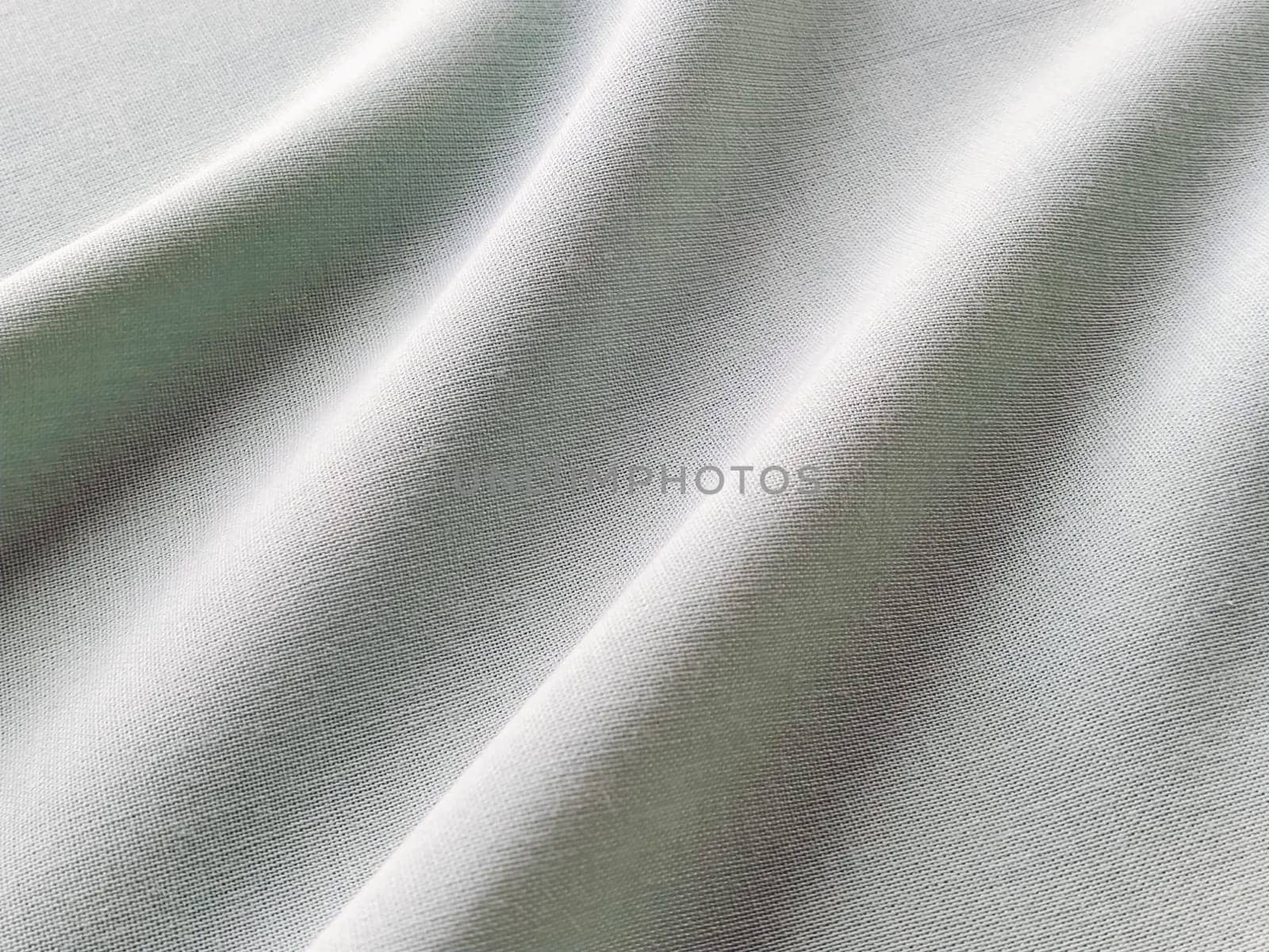 Beautifully folded fabric. Soft pleasant waves and flounces on textiles. Close-up. Drapery for curtains, fabric for dressmaking or upholstery. Black and white monochrome image