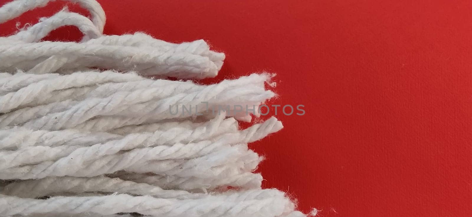 Cotton Rope Wringer Mop Attachment. The material is wrung out with a single rotary motion, avoids getting hands dirty and shortens the cleaning time. The cotton nozzle absorbs water. Red background.