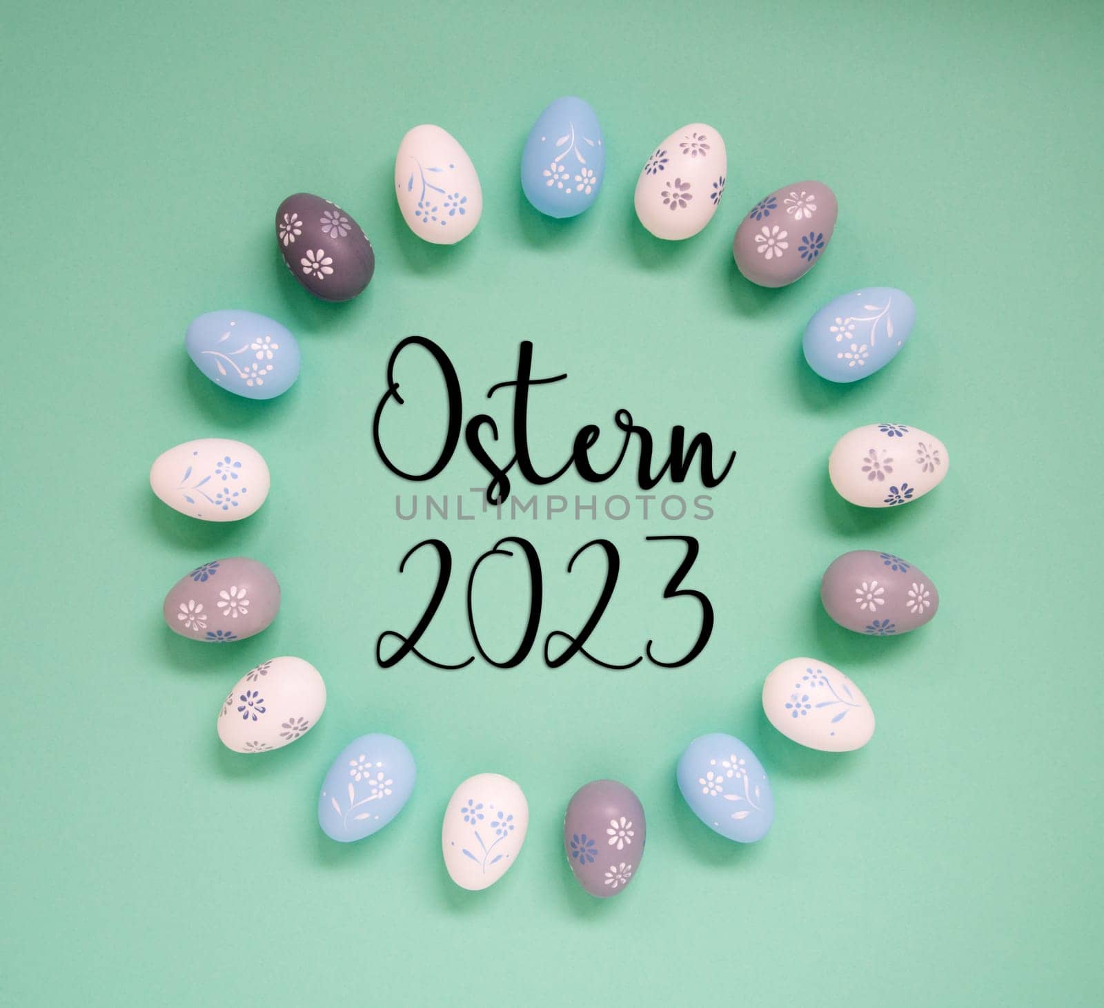 Flat Lay With German Text Ostern 2023 Means Easter 2023. Easter Egg Arrangement, Decoration And Ornament. Light Green Paper Background
