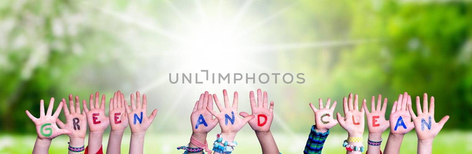 Children Hands Building Colorful English Word Green And Clean. Sunny Green Grass Meadow As Background.