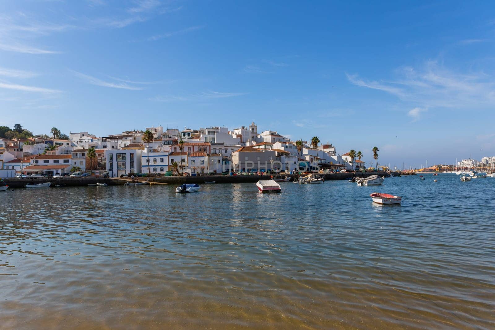 Ferragudo, Portugal - August 25, 2022 - View of the white town with boats moored in the foreground, Ferragudo, Algarve, Portugal, Europe