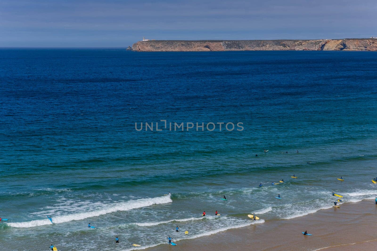 Sagres, Portugal - August 25, 2022: View of surfers on sandy beach near Sagres village in Algarve, Portugal