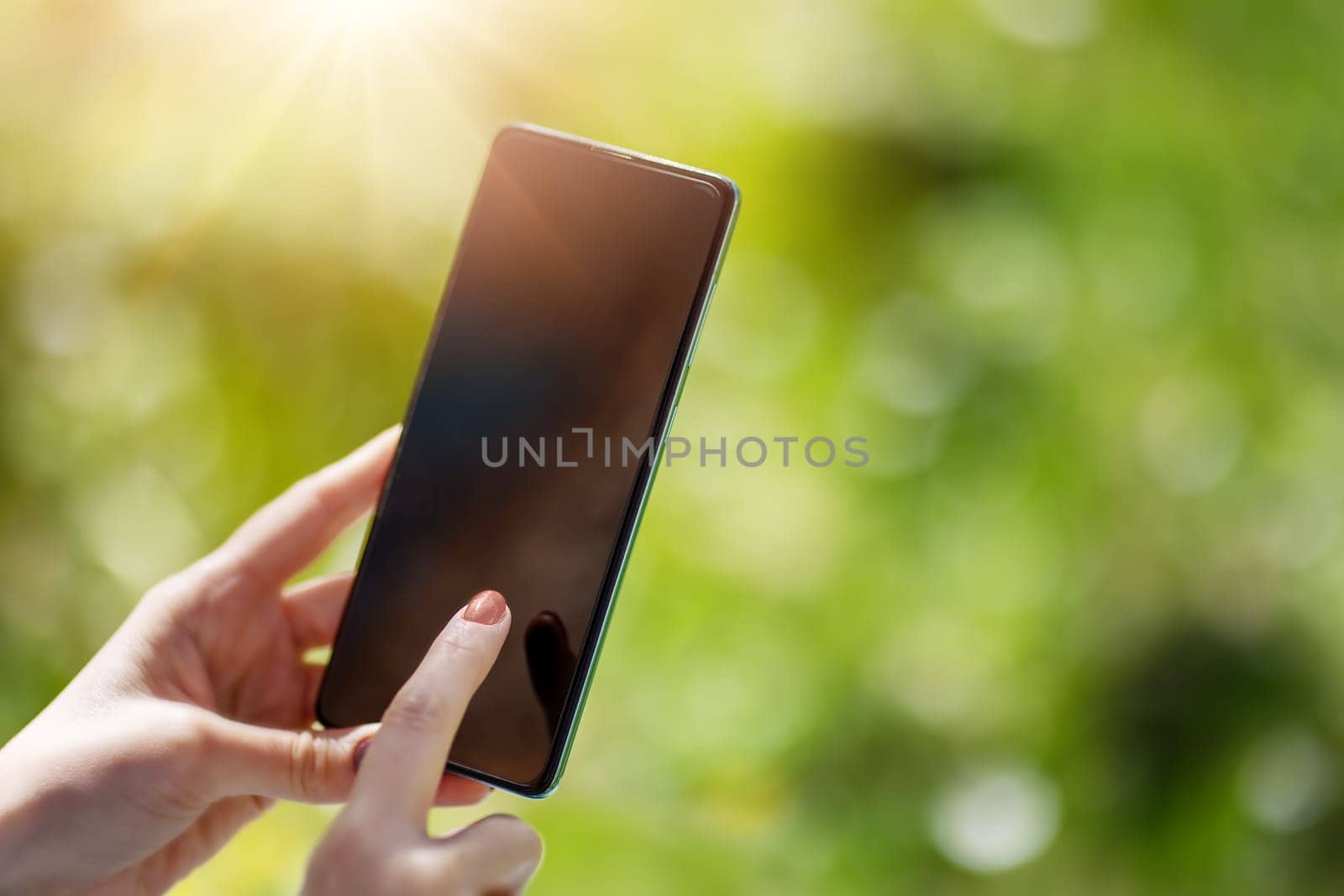 Closeup view of the woman's hands holding smartphone. Concept of the background, wallpaper and backdrop.