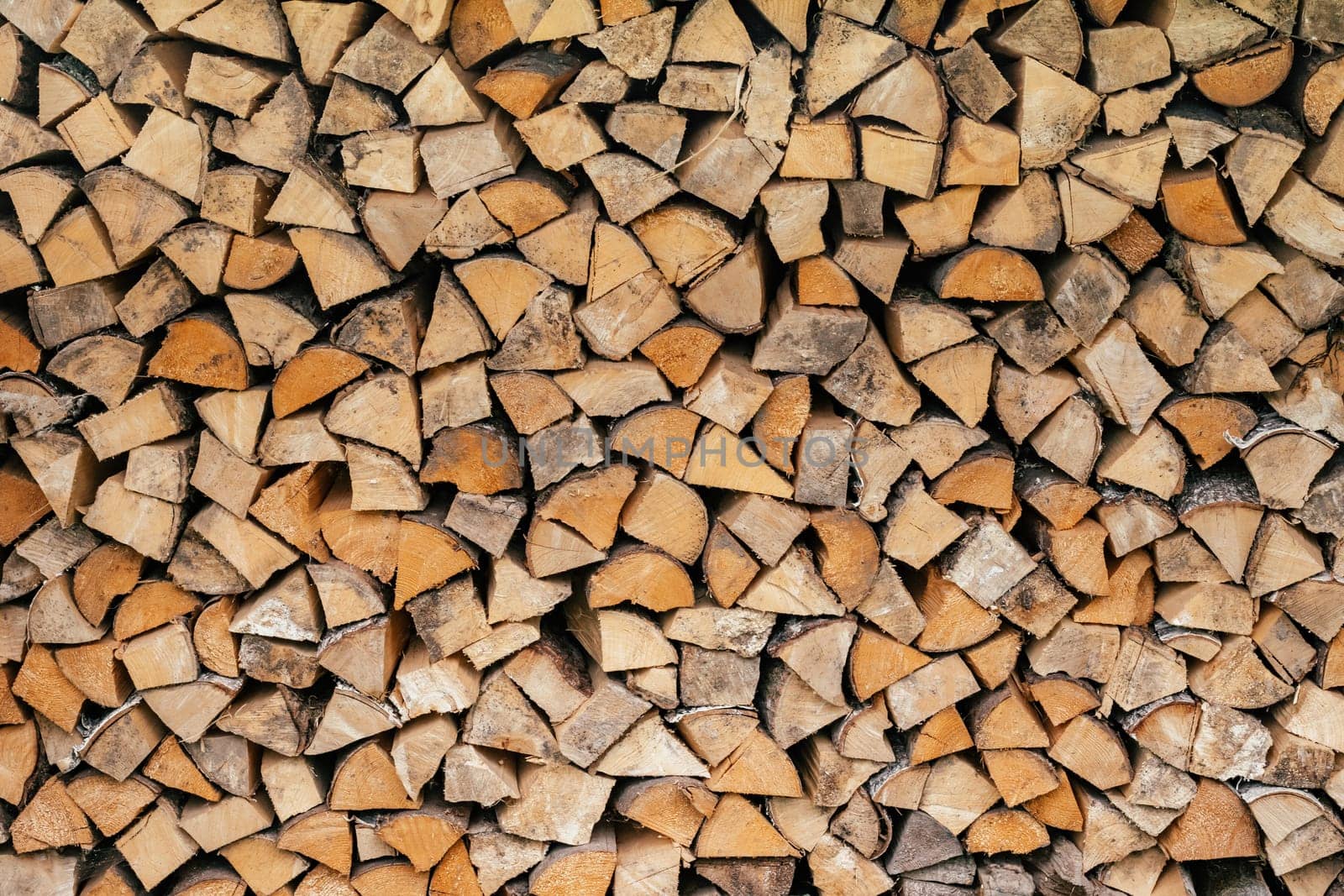 Texture background image of chopped firewood stacked in a woodpile. Copy space