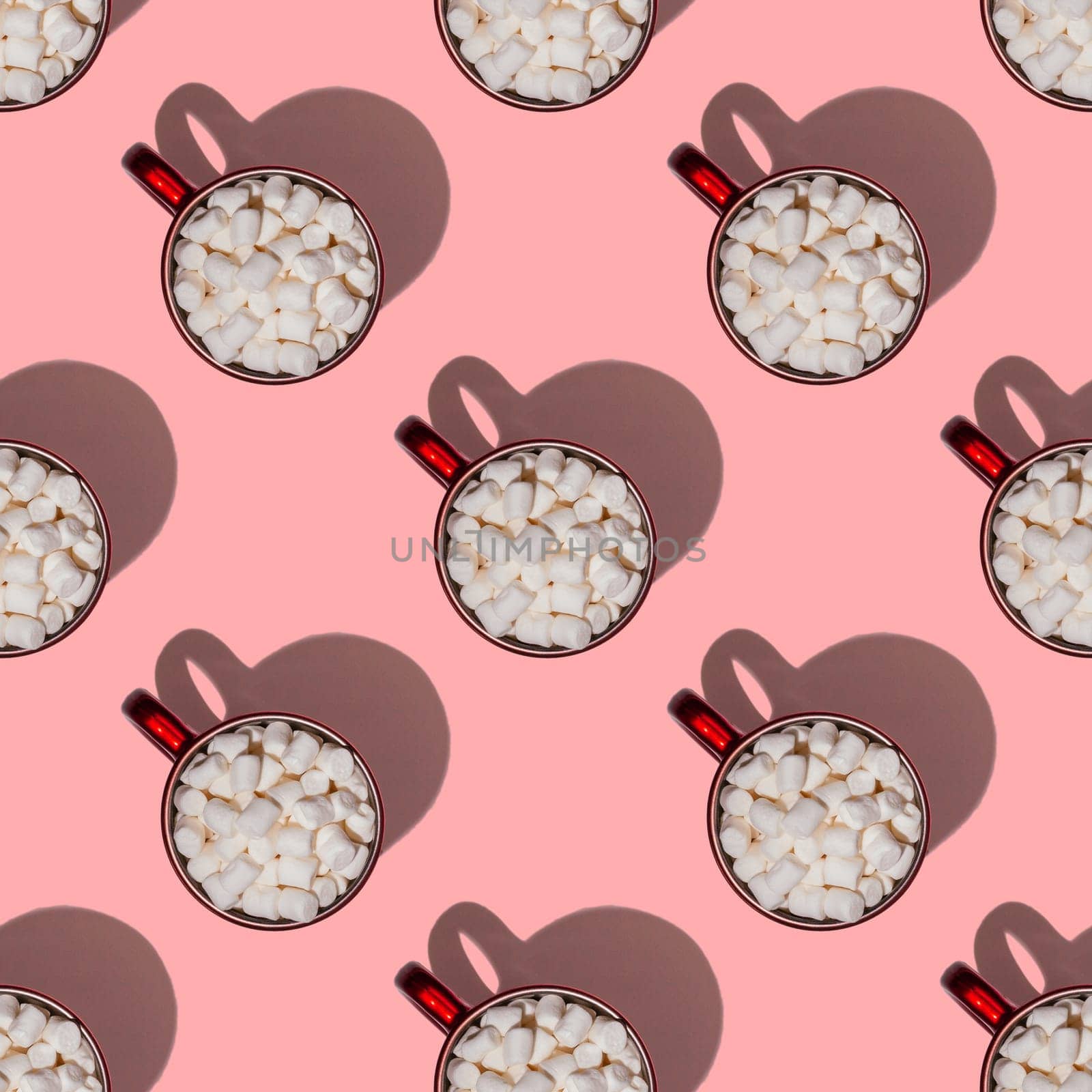 Seamless endless pattern of red cups with hot chocolate, coffee or cocoa with marshmallows with hard shadows isolated on light pink background. Top view