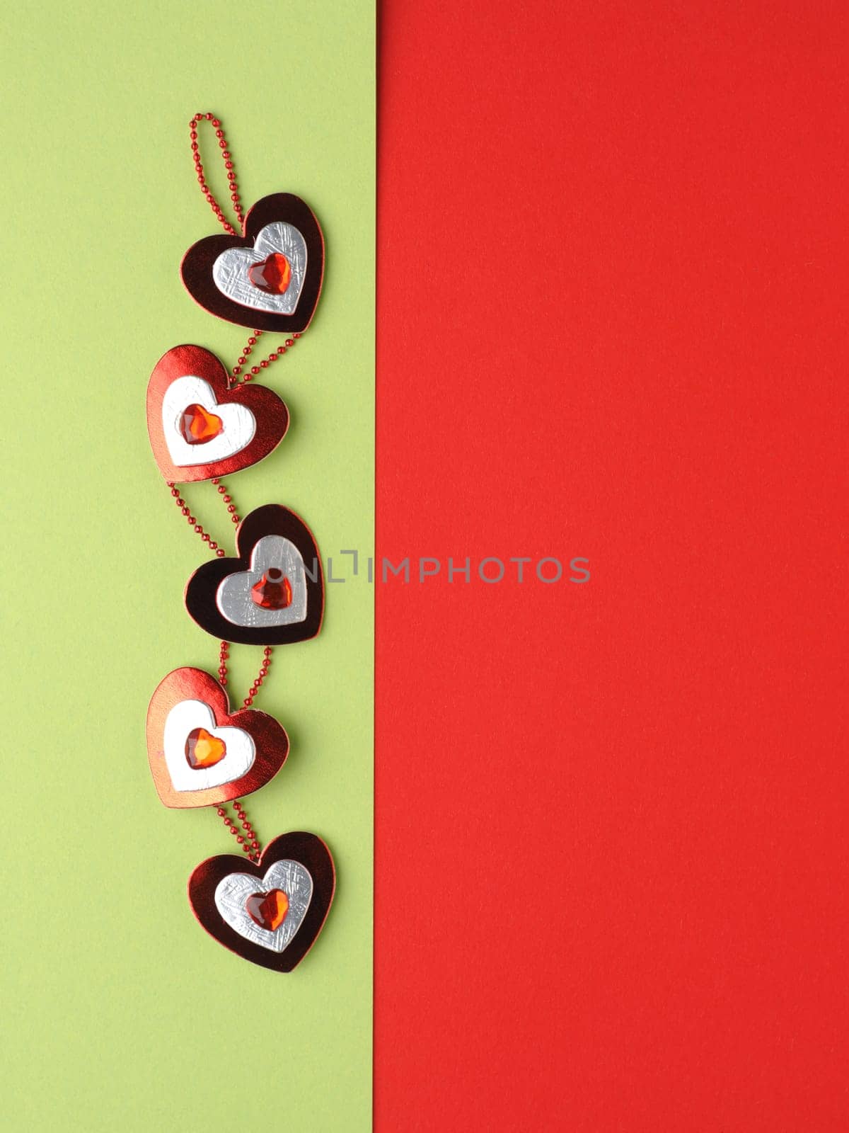 Heart decoration on green and red paper background with space for text