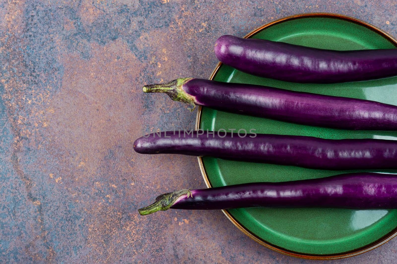 Raw small eggplants on the kitchen table.