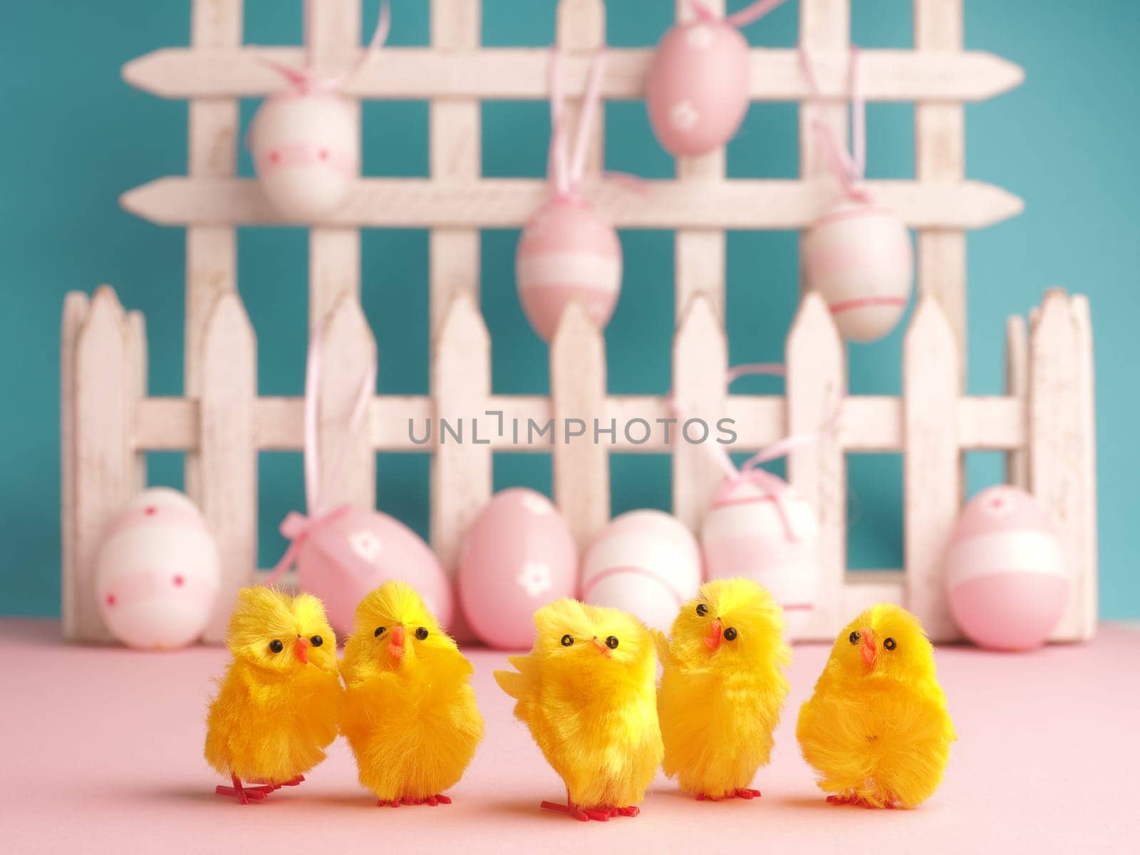 Close up of five cute chicks with Easter eggs background