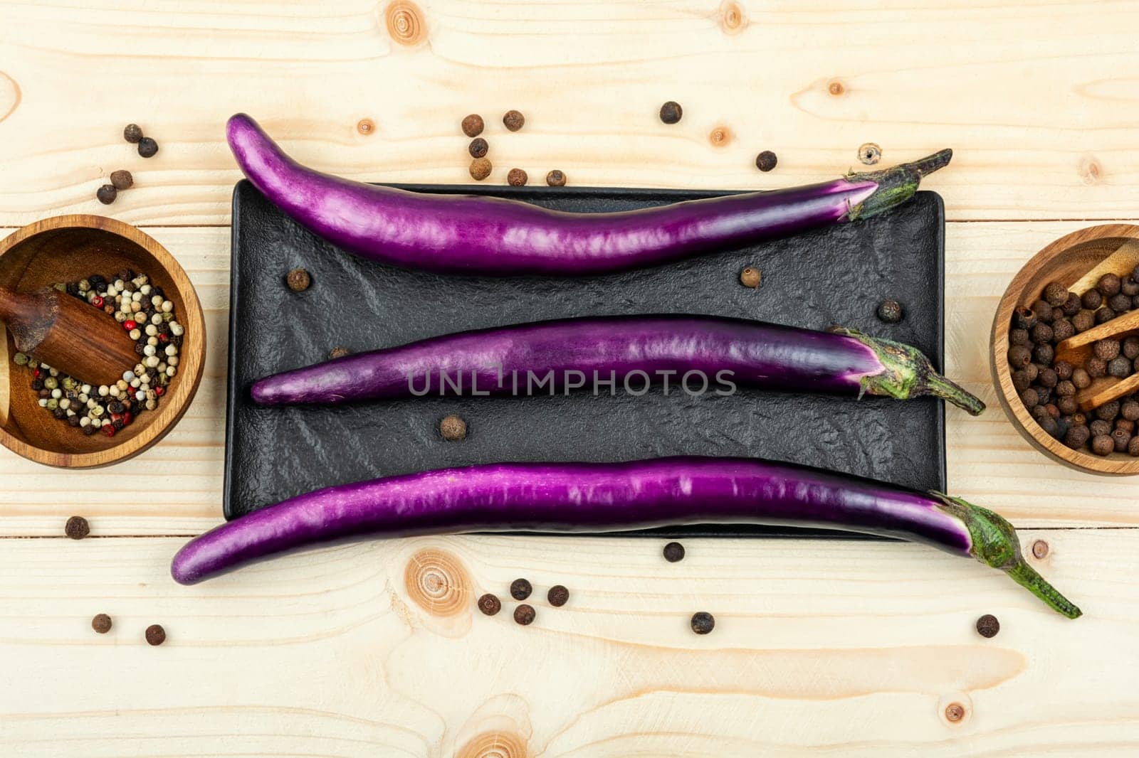 Raw small eggplants on the kitchen table.