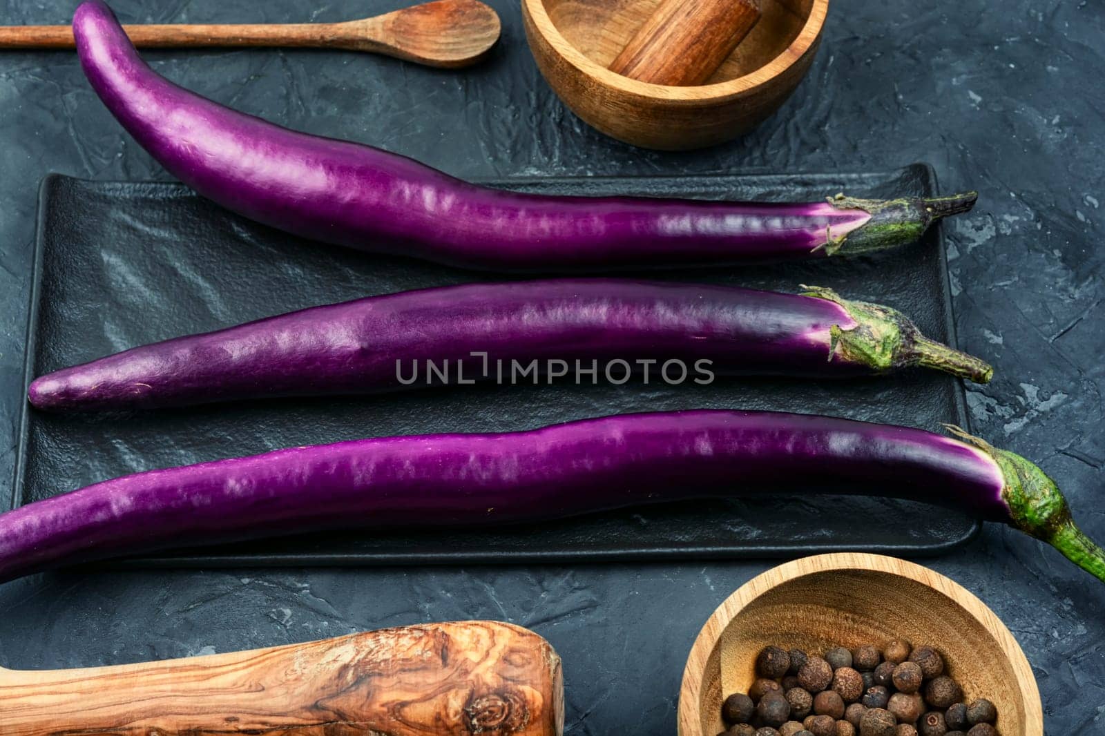 Raw small eggplants on the kitchen table.