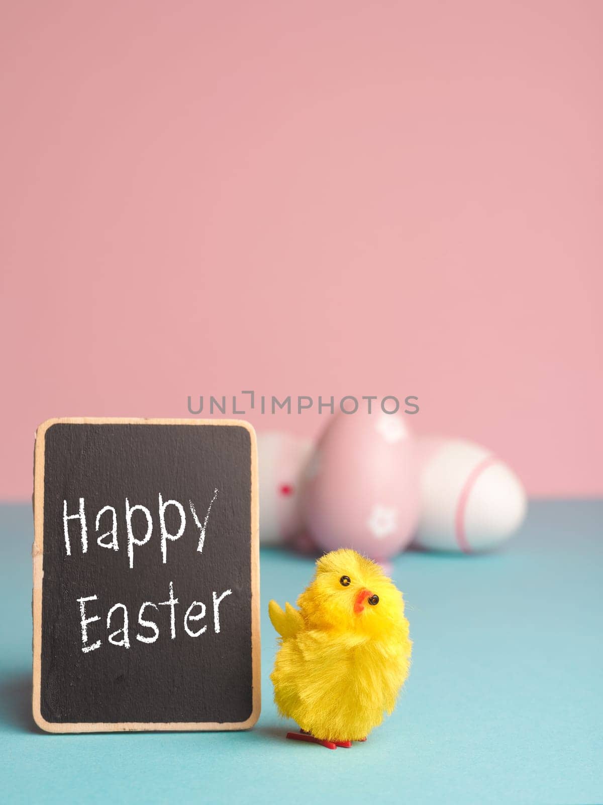 Close up of a cute chick with the words Happy Easter and an Easter egg background