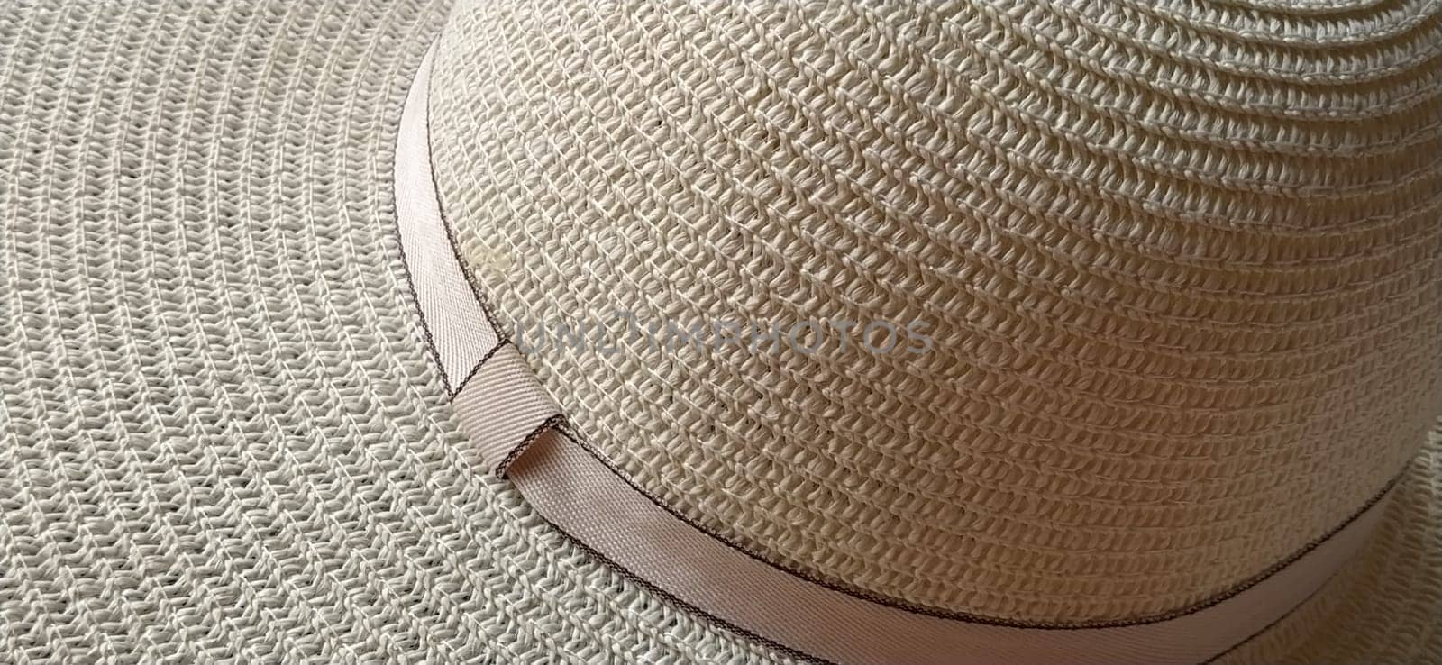 Hatband. A strap or adornment on the headdress. Straw hat close-up. Travel and leisure theme. Summer holiday. View from above
