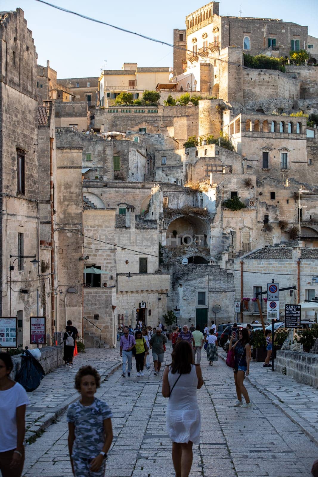 Matera, Italy - September 14, 2019: Tourists during a walk on Cobblestone street in the Sassi di Matera a historic district in the city of Matera. Basilicata. Italy