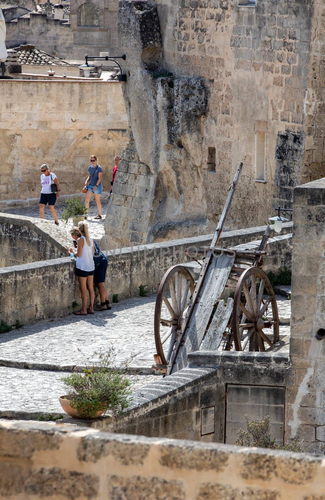 Matera, Italy - September 15, 2019: Tourists during a walk on Cobblestone street in the Sassi di Matera a historic district in the city of Matera. Basilicata. Italy