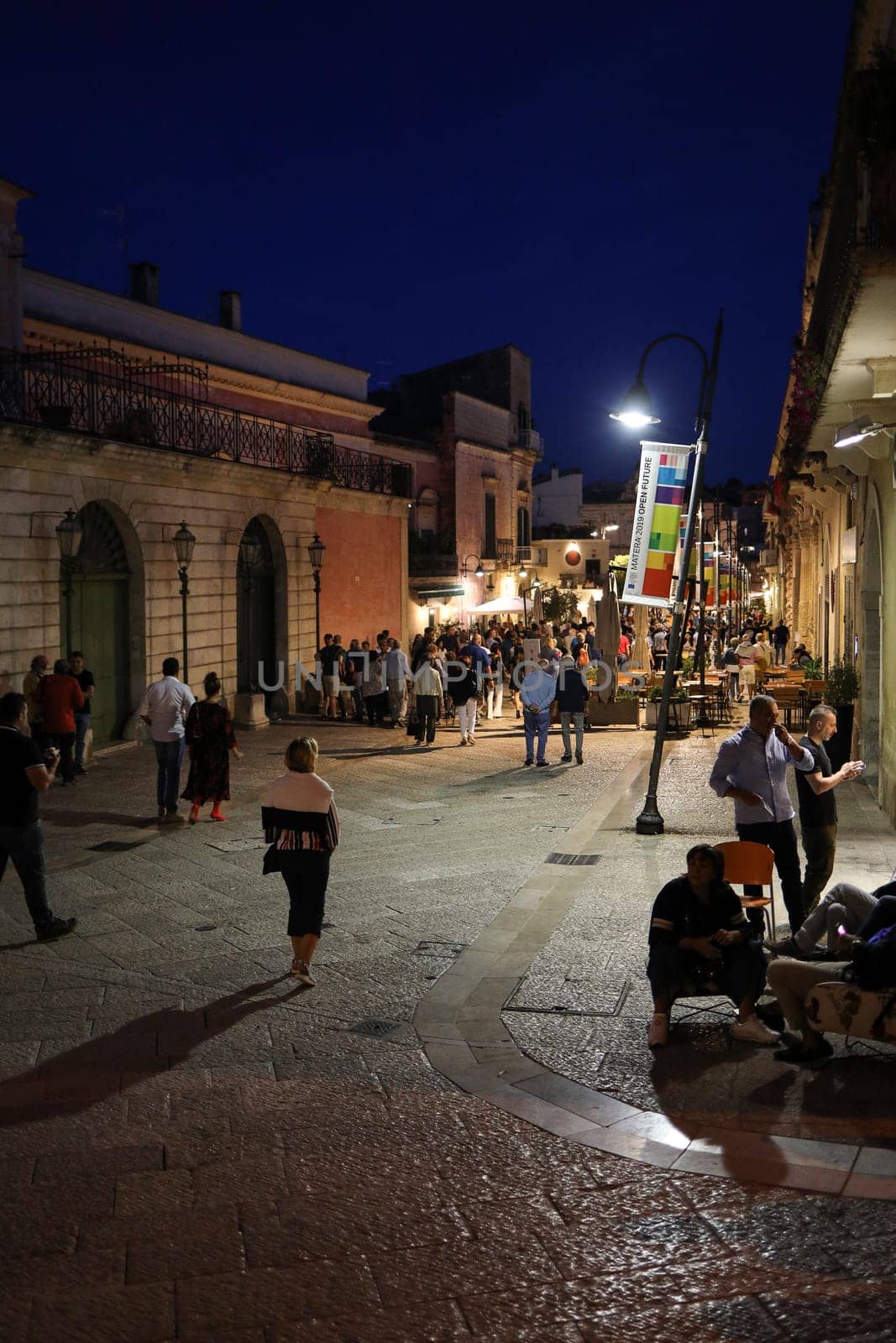 Matera, Italy - September 15, 2019: Tourists during a walk on Cobblestone street in the Sassi di Matera a historic district in the city of Matera. Basilicata. Italy