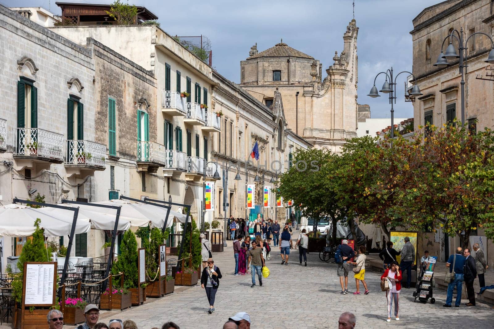 Matera, Italy - September 15, 2019: Tourists during a walk on Cobblestone street in the Sassi di Matera a historic district in the city of Matera. Basilicata. Italy