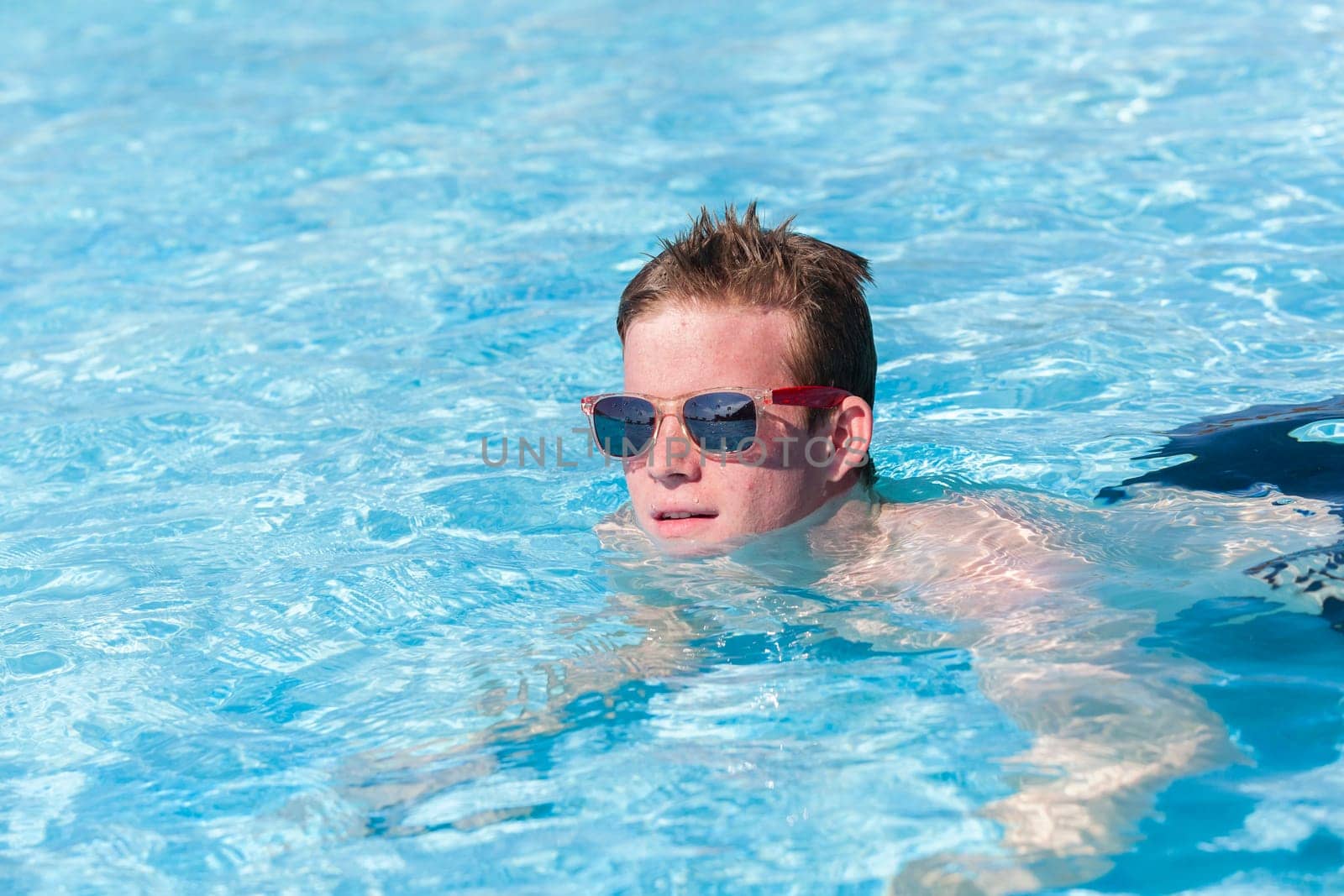 Boy teenager swimming pool summer fun.