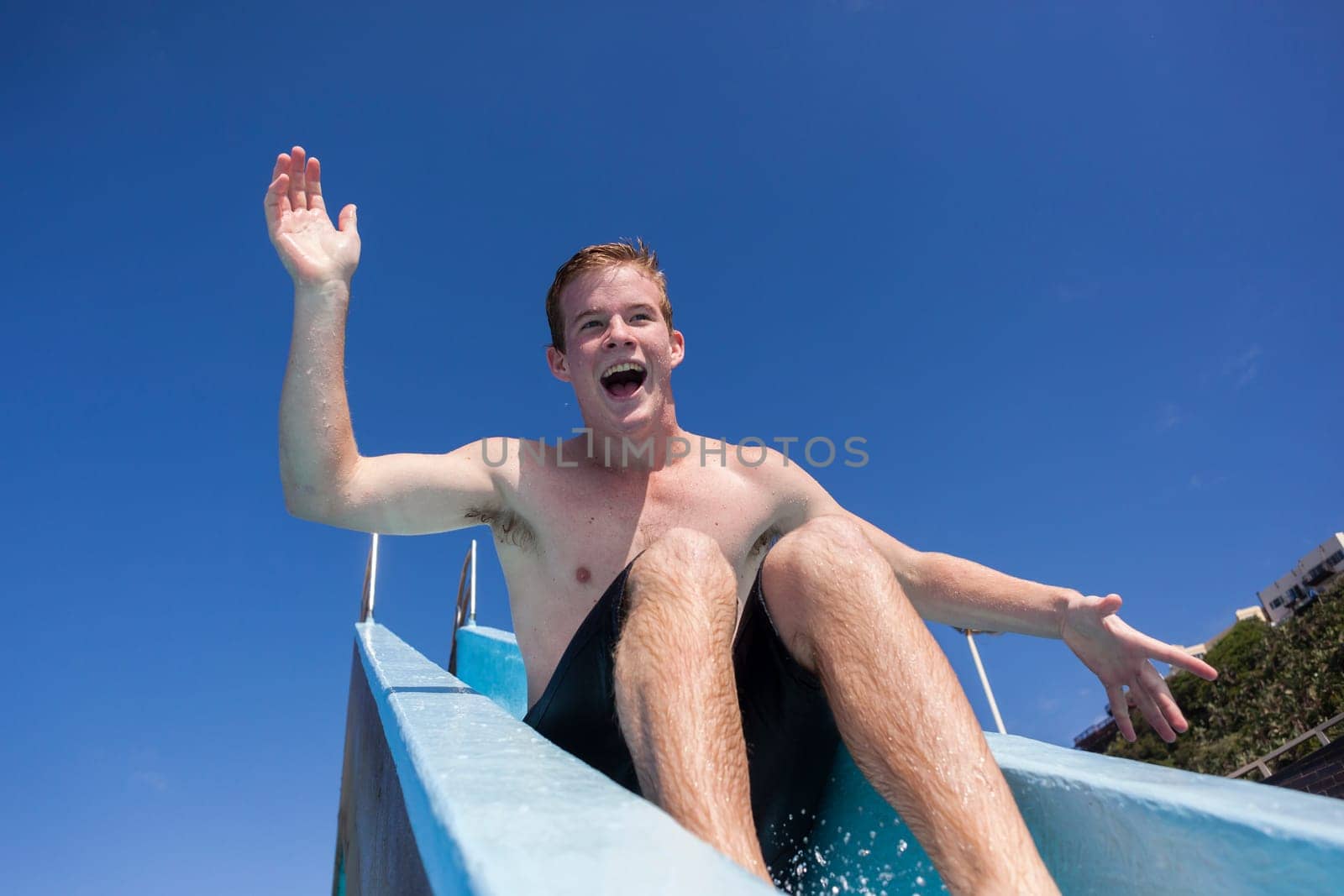 Boy teenager swimming pool summer fun.