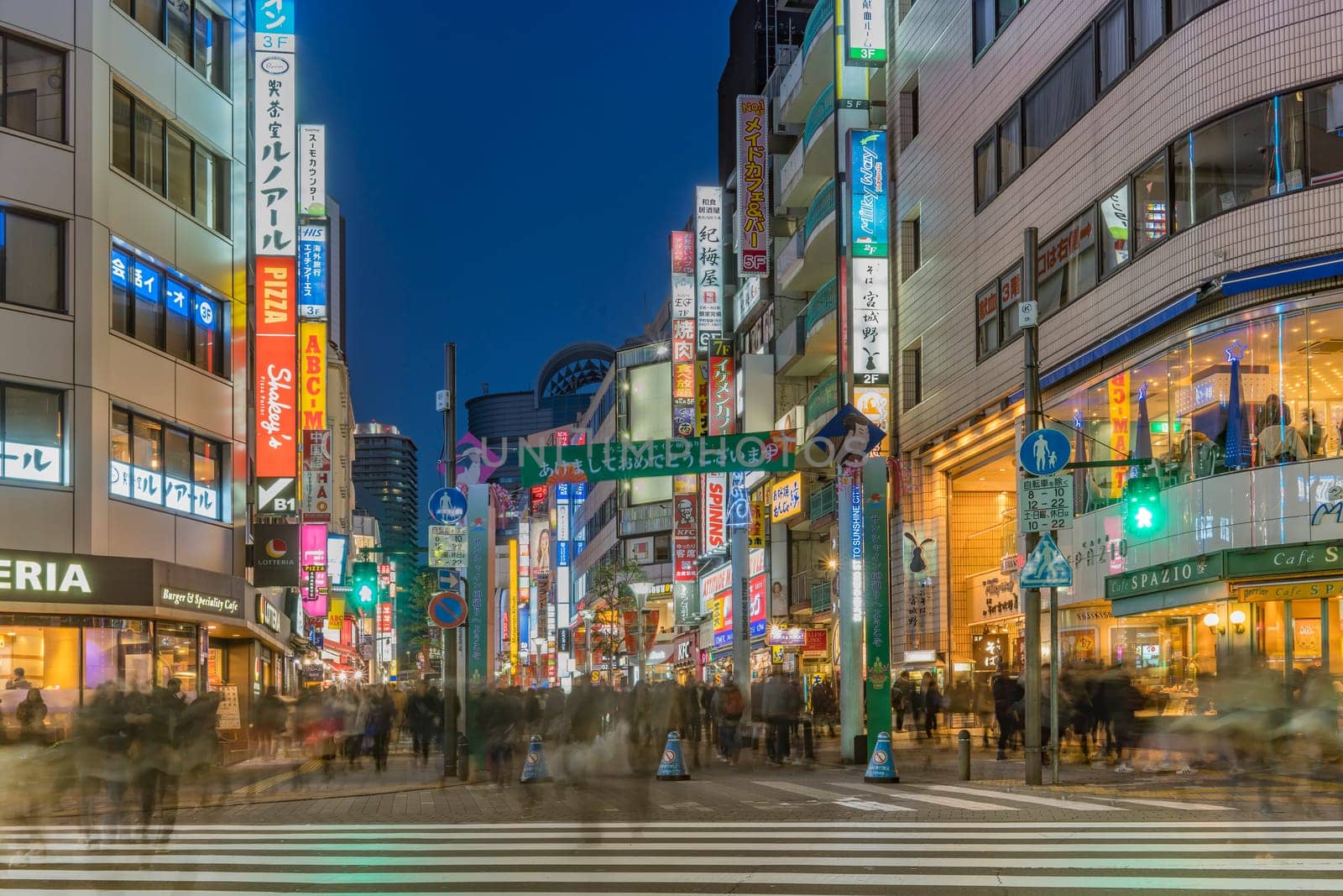 ikebukuro, japan - december 31 2019: Night view of the crowd on the pedestrian crossing of the Sunshine 60 Street leading to the famous otome road decorated for the cebrations of the new year.