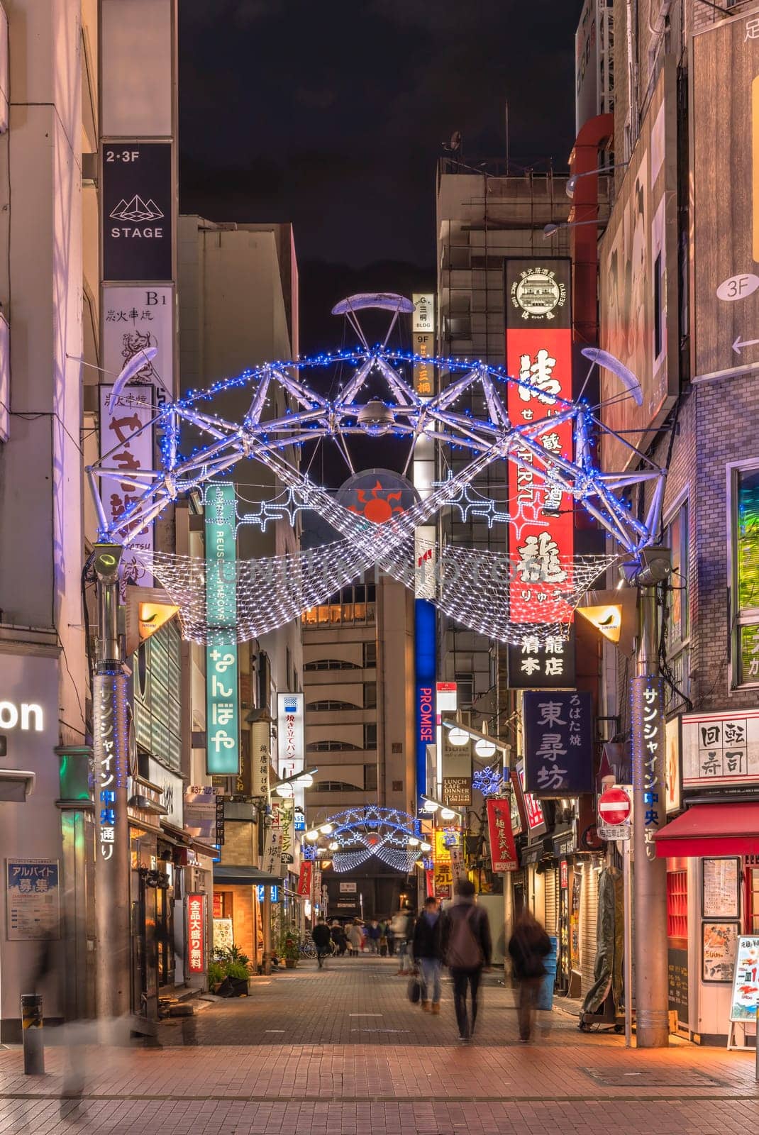 ikebukuro, japan - december 31 2019: Night view of the illuminated entrance gate of the Sunshine Central Street connecting the east exit of Ikebukuro station lines with restaurants and shops leading to the famous otome road decorated for new year.