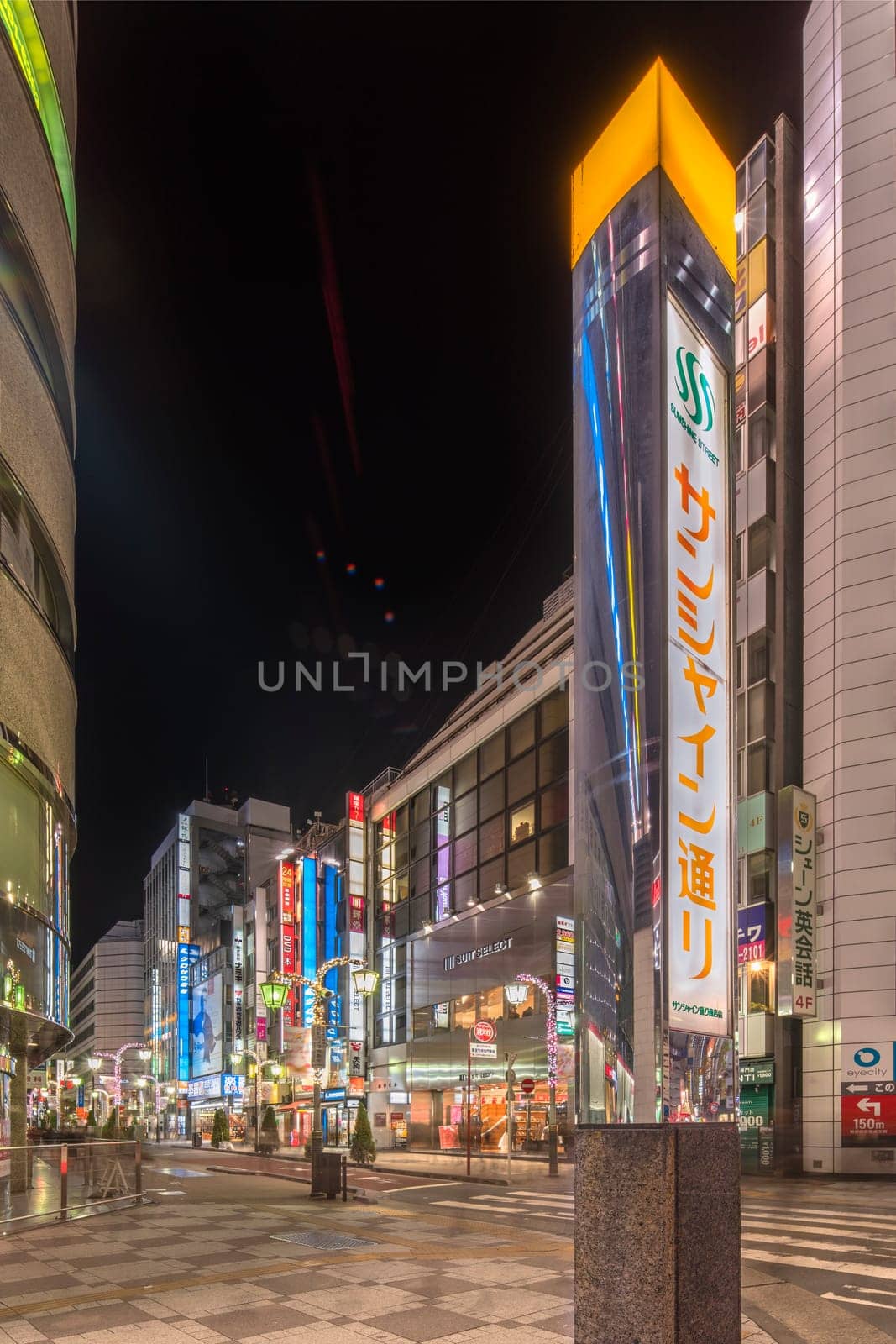 ikebukuro, japan - december 31 2019: Metal pole with the name of the Sunshine Street which connects the east exit of Ikebukuro train station to the otome road during Christmas and New Year at night.