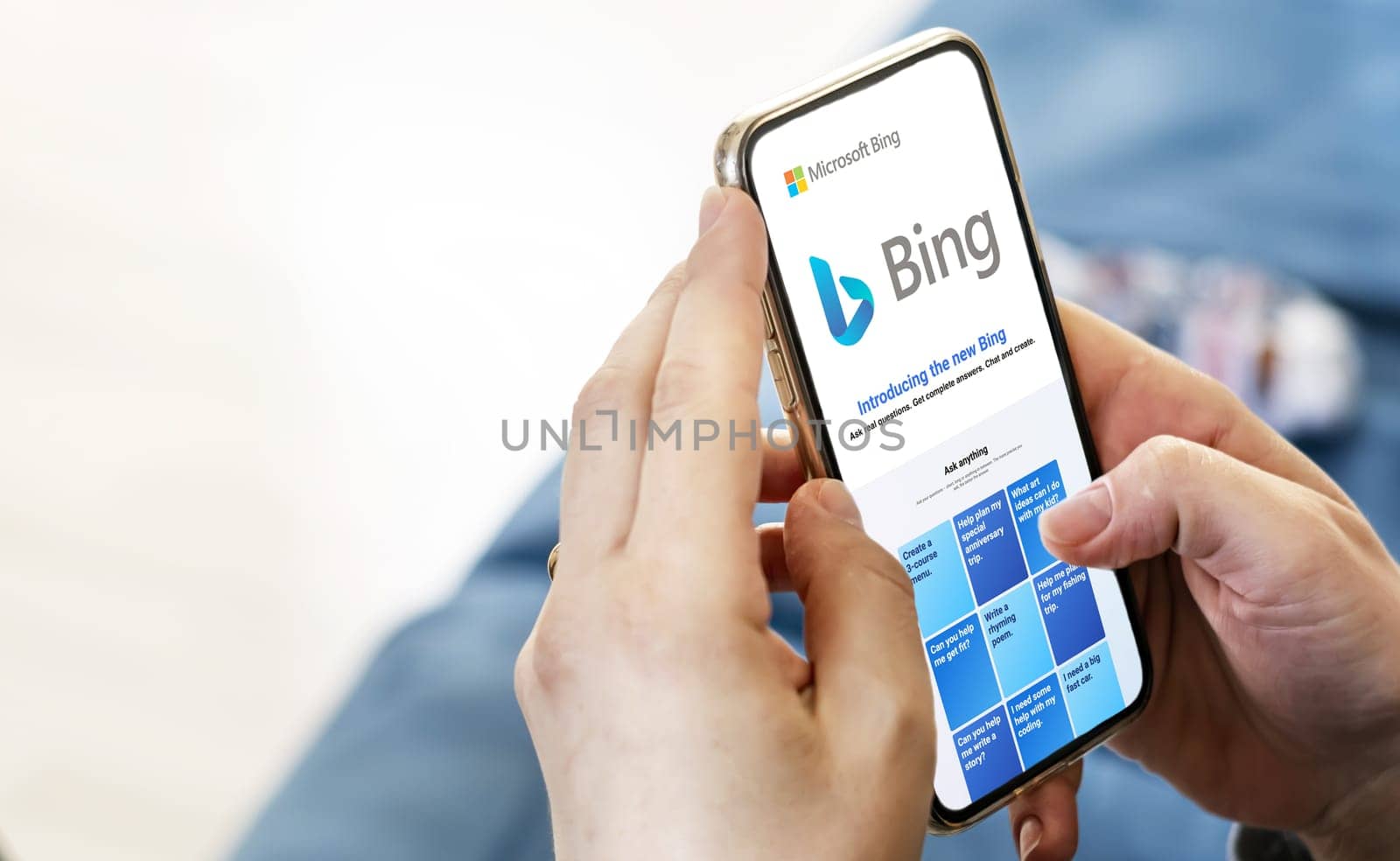 Redmond, US, Feb 2023: Female hands holding a phone with the Microsoft Bing website on the screen. Interior shot. Bing is a search engine recently integrated with AI chatbot. Illustrative editorial