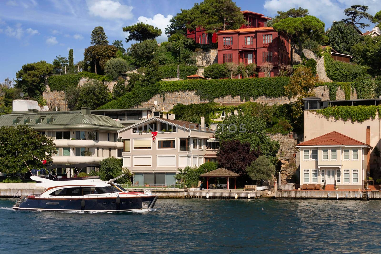 View from Bosphorus strait of the green mountains of the Asian side, with traditional houses and dense trees in a summer day, Istanbul, Turkey