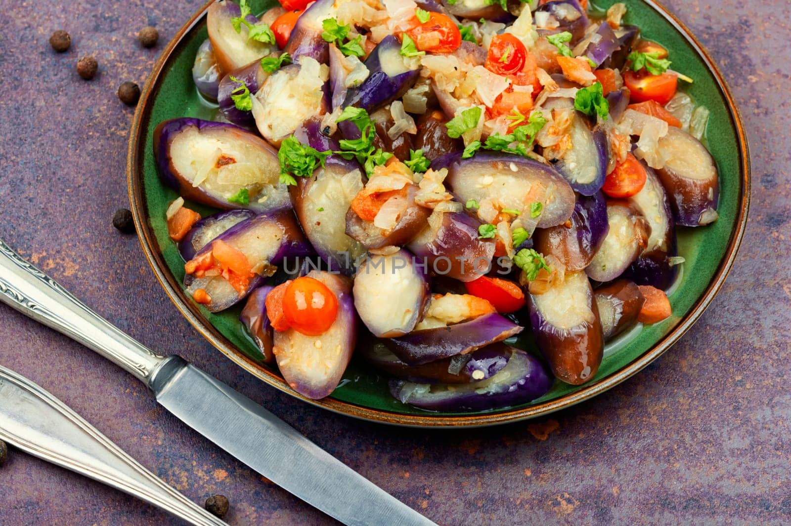 Warm purple eggplant, tomato and garlic salad. Salad of baked vegetables. Copy space for text