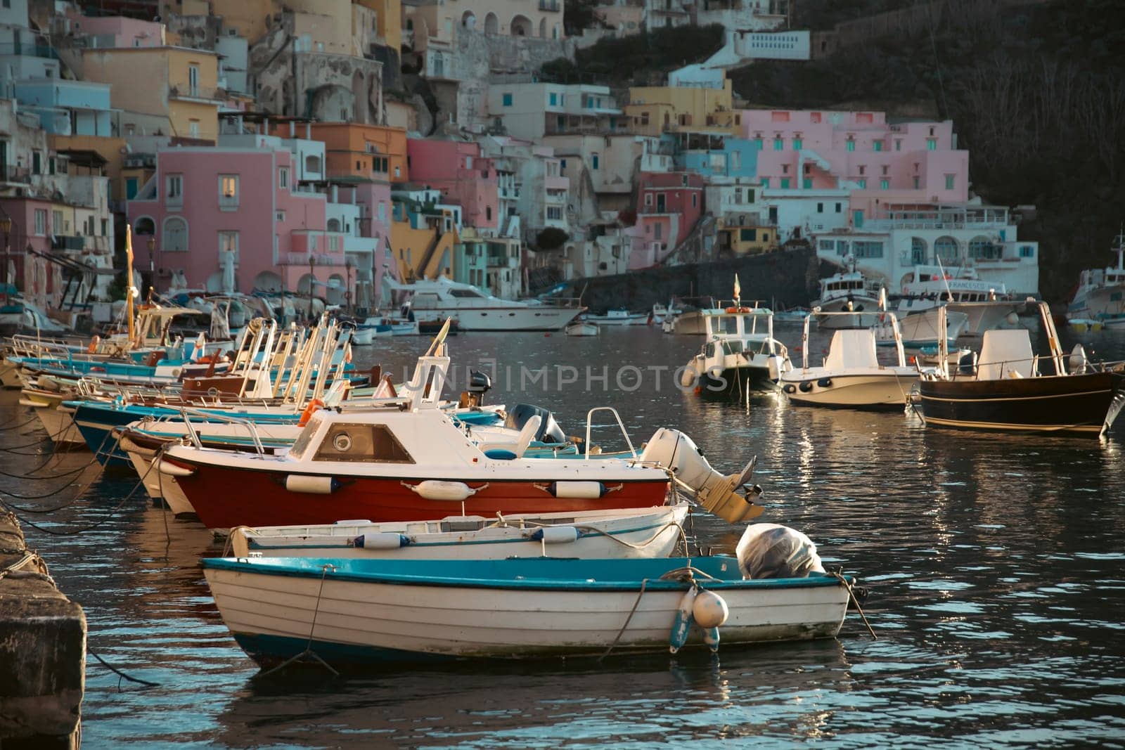 View of the Port of Corricella with lots of colorful houses on a sunny day in Procida Island, Italy.