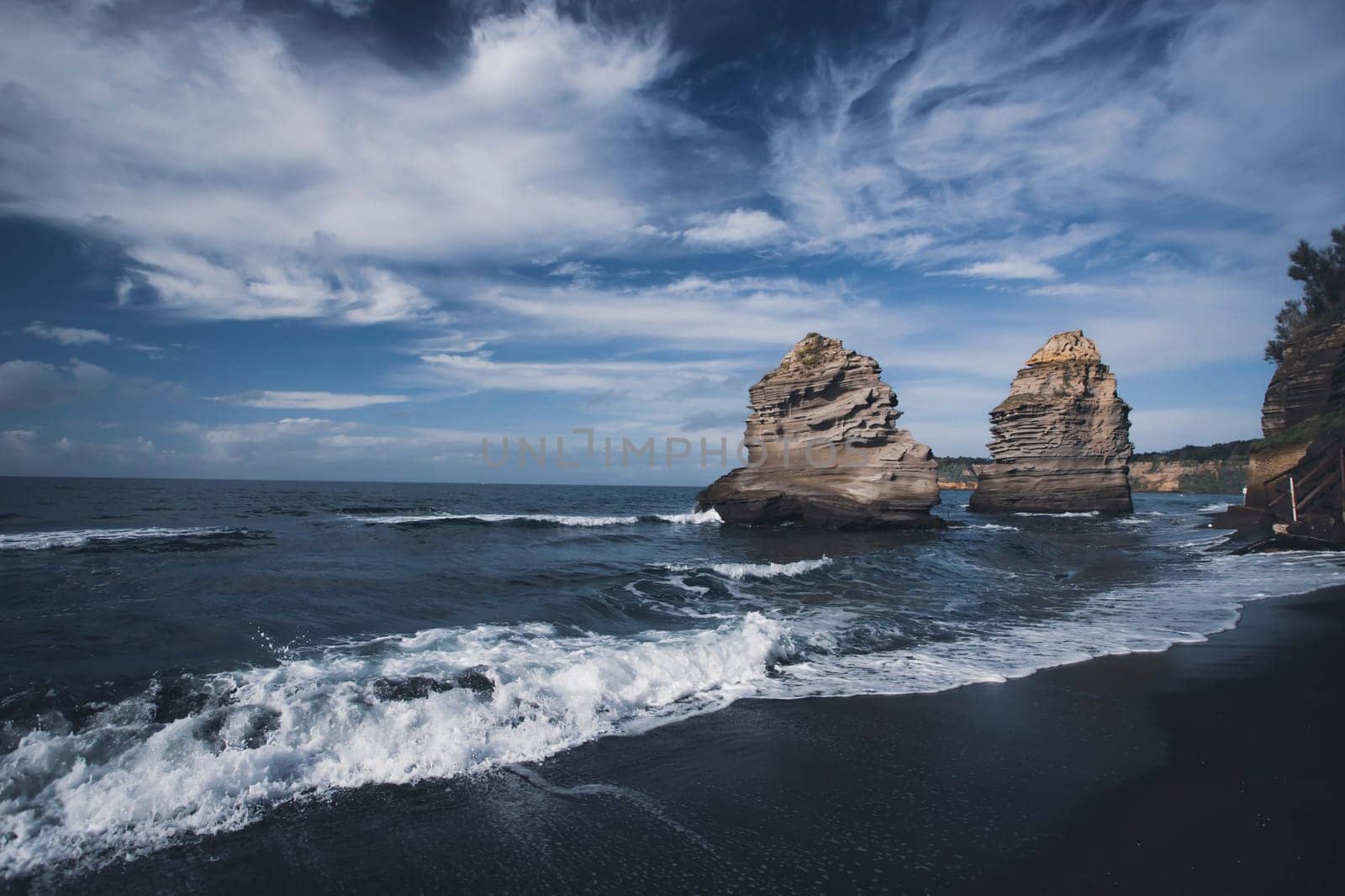 The black Ciraccio beach with the rock formations shaped by the wind on the northwest coast of the island of Procida in the Gulf of Naples