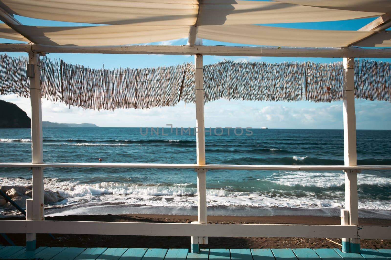 Cozy terrace on the beach, idyllic view of the seashore. Tropical summer vacation concept.