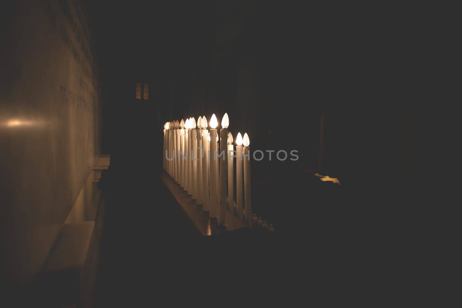 Many burning candles with shallow depth of field in a church