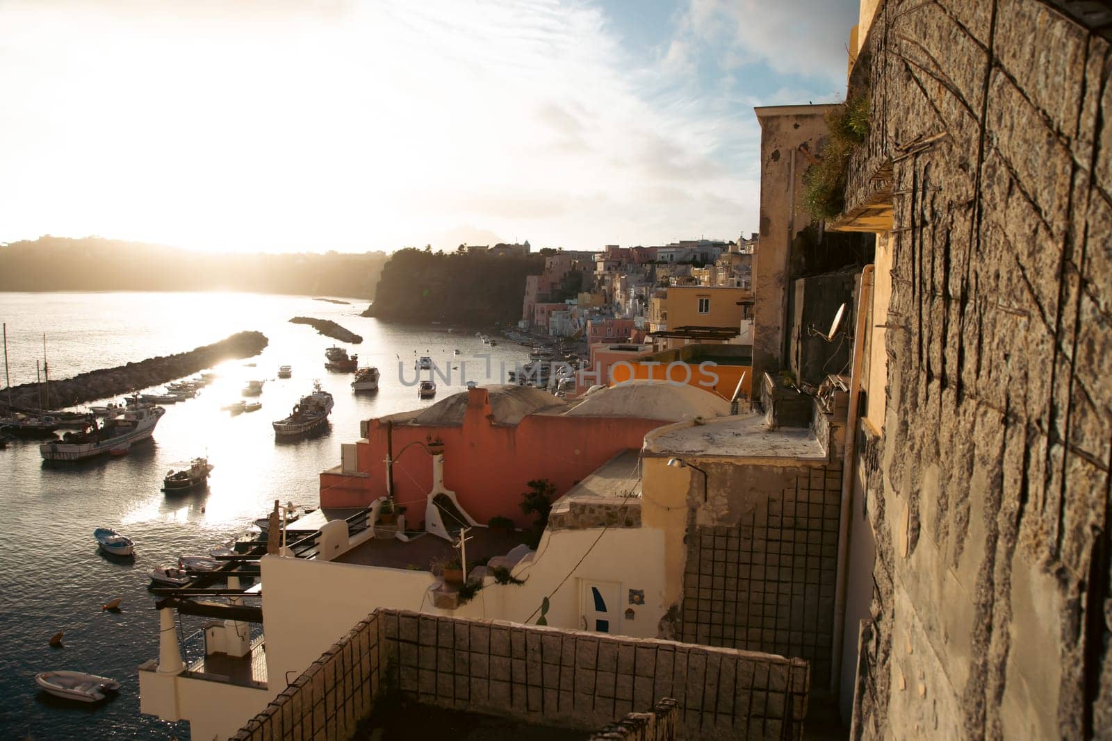 View of the Port of Corricella with lots of colorful houses on a sunny day in Procida Island, Italy.