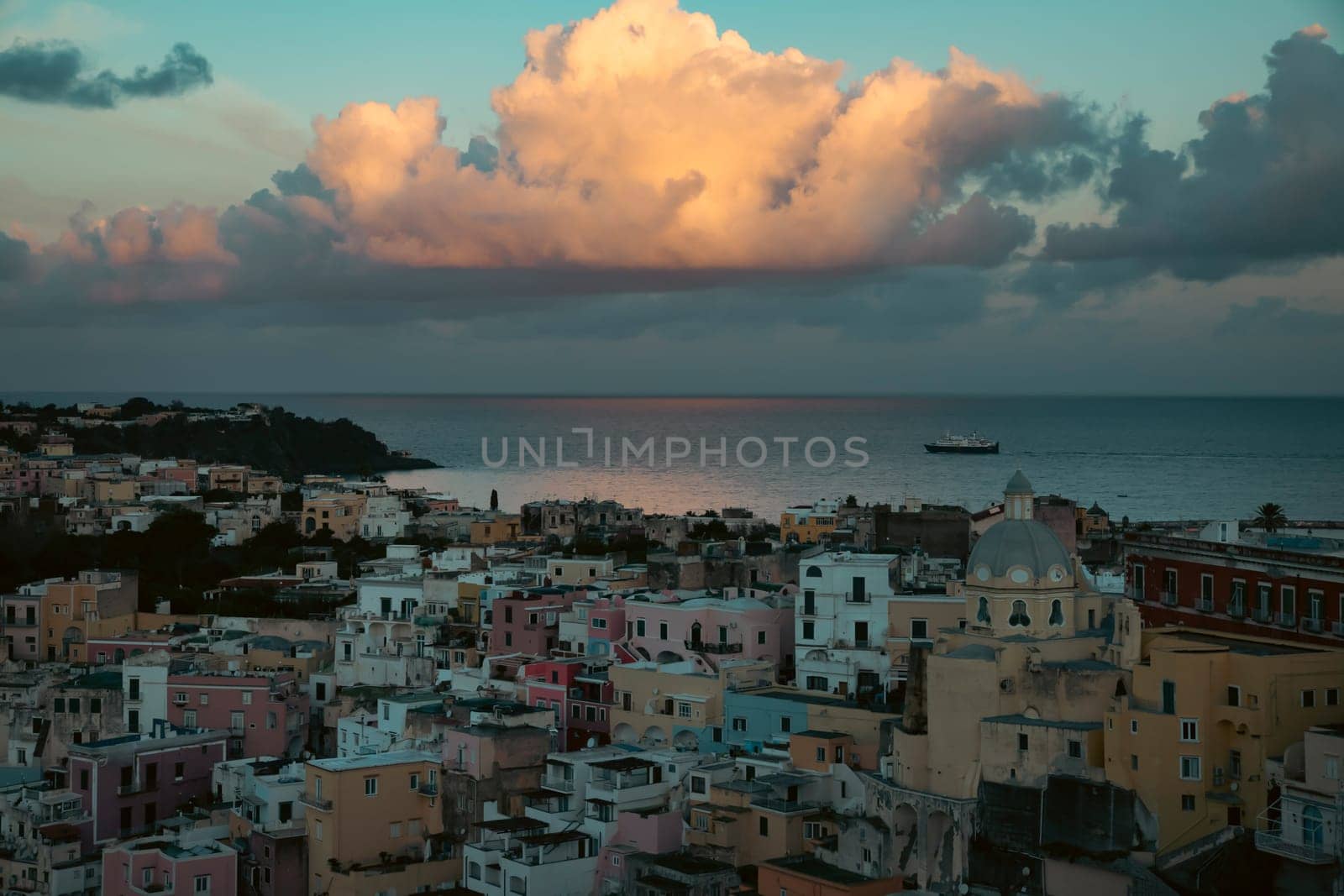 View of the Port of Corricella with lots of colorful houses in the sunset in Procida Island, Italy.
