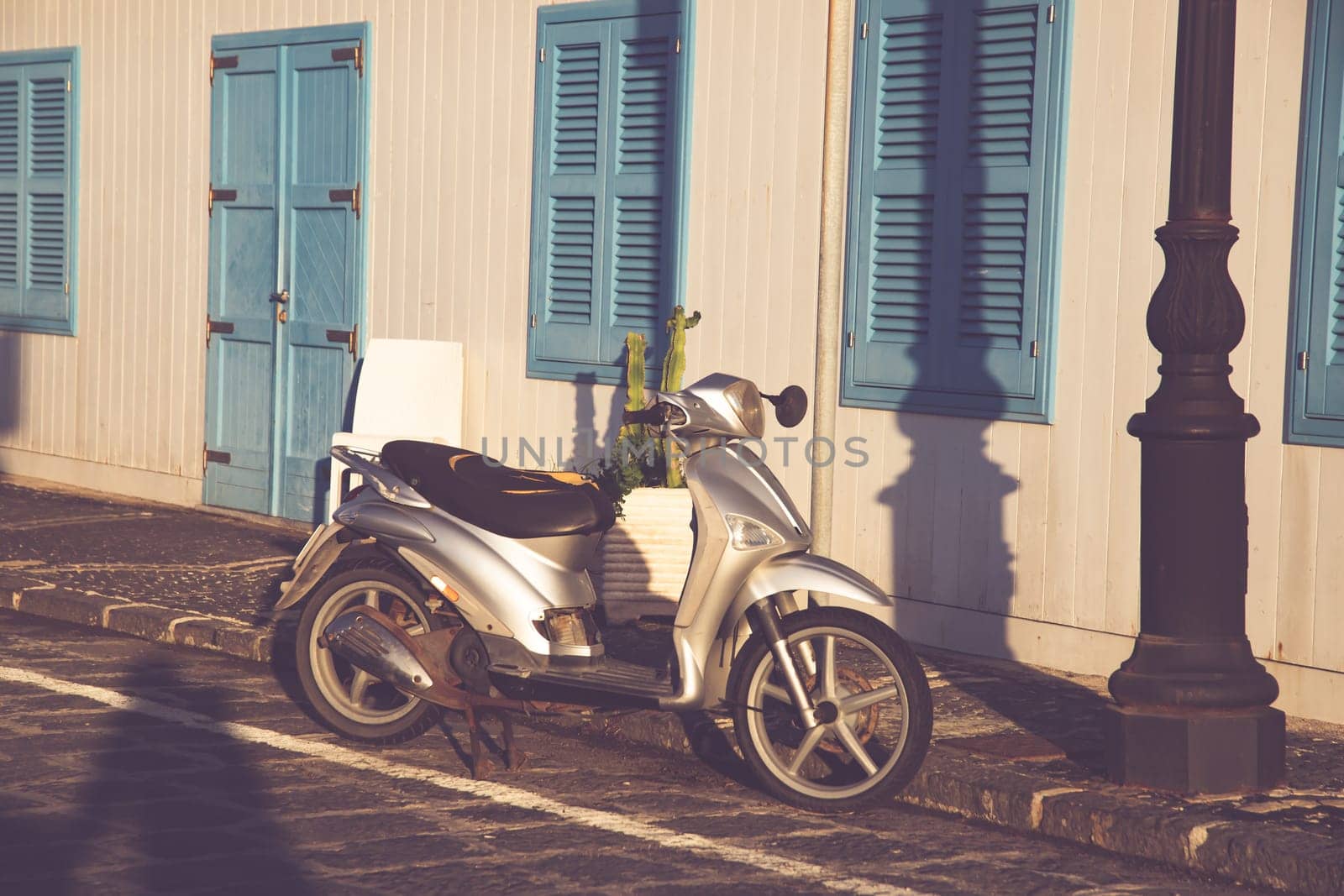 Typical street scene in Procida with an old scooter on a narrow cobblestoned street.