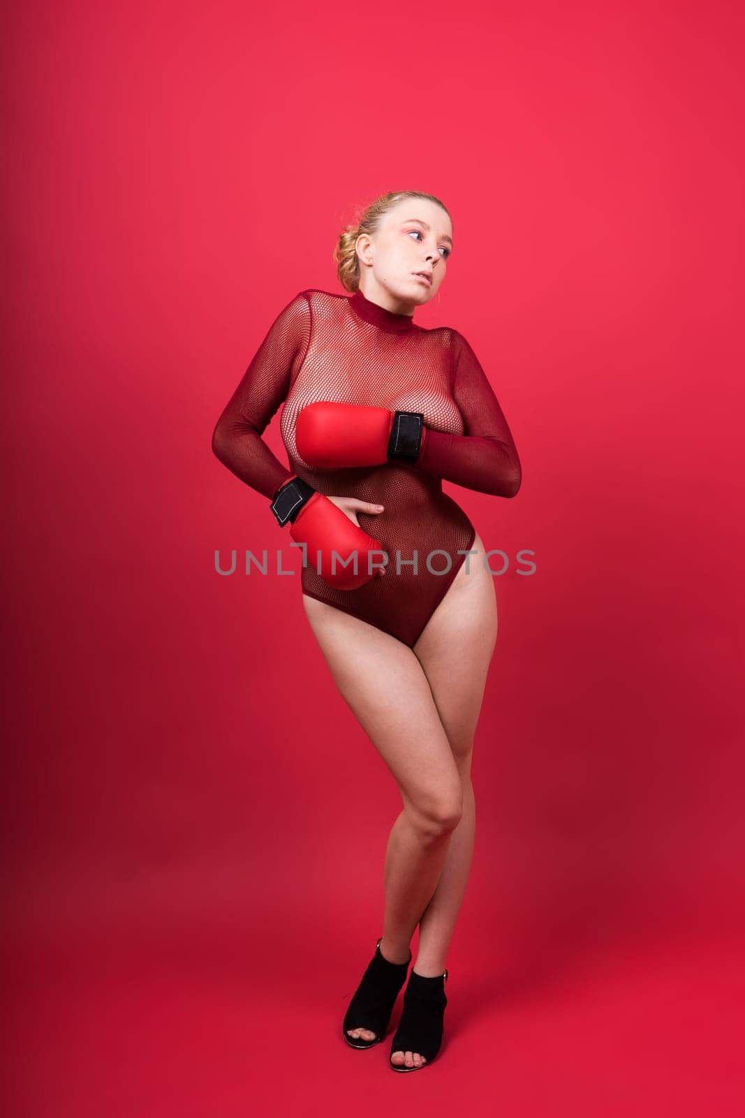 A beautiful, attractive, seductive girl with blonde hair in a studio.