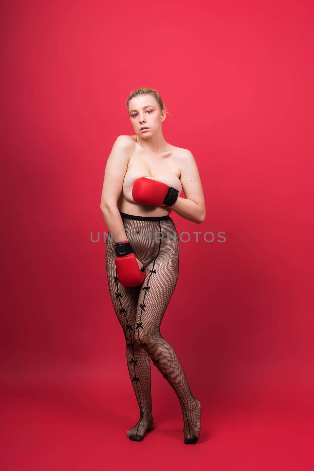 A beautiful, attractive, seductive girl with blonde hair in a studio.