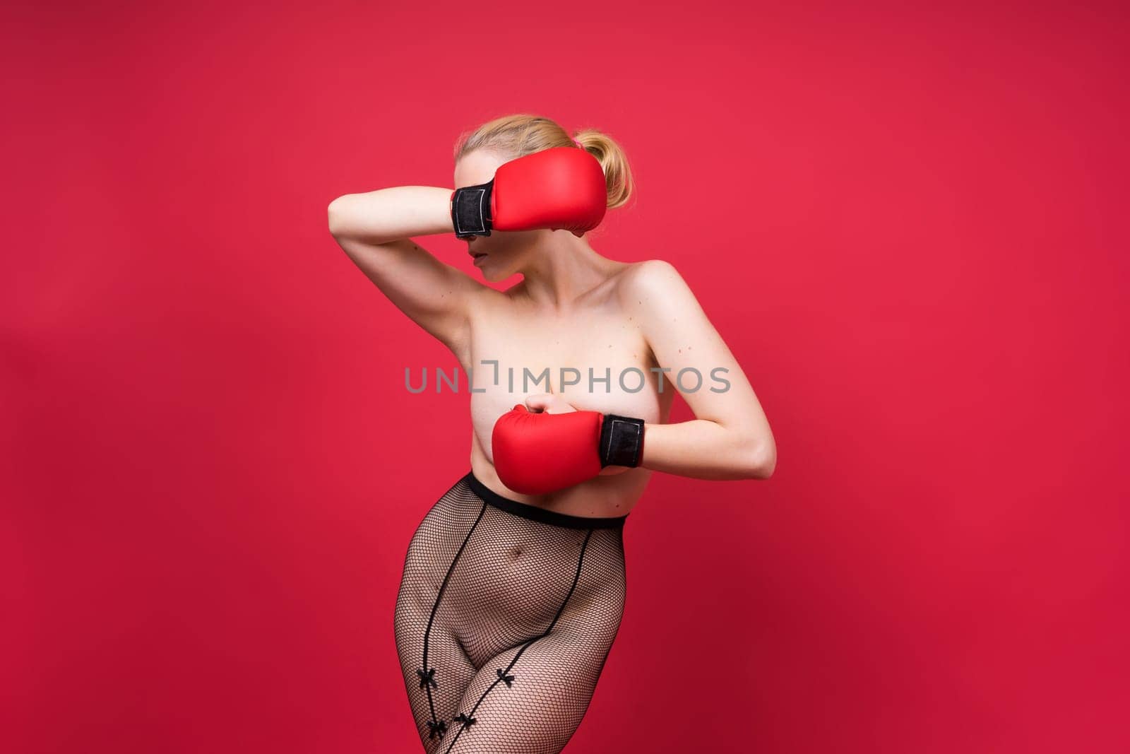 A beautiful, attractive, seductive girl with blonde hair in a studio.
